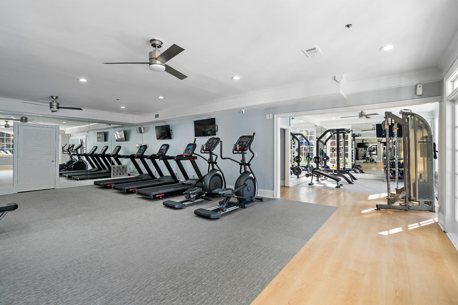 A spacious gym with treadmills, elliptical machines, and other exercise equipment.