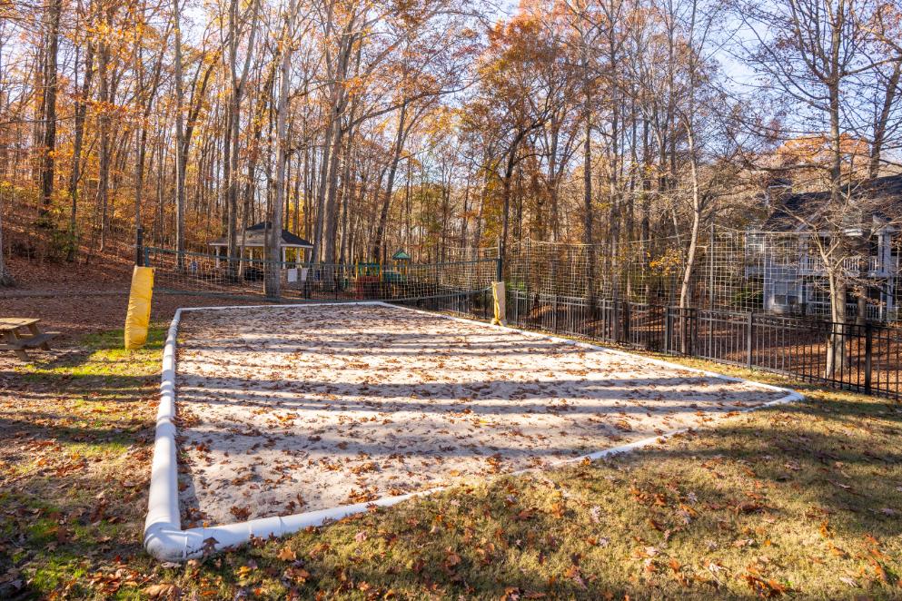 A playground with a white fence and a yellow post.