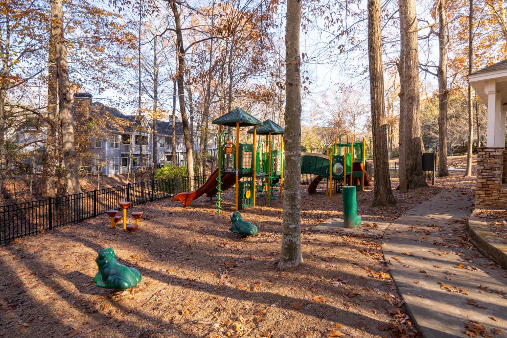 A playground with a green slide and a red slide.