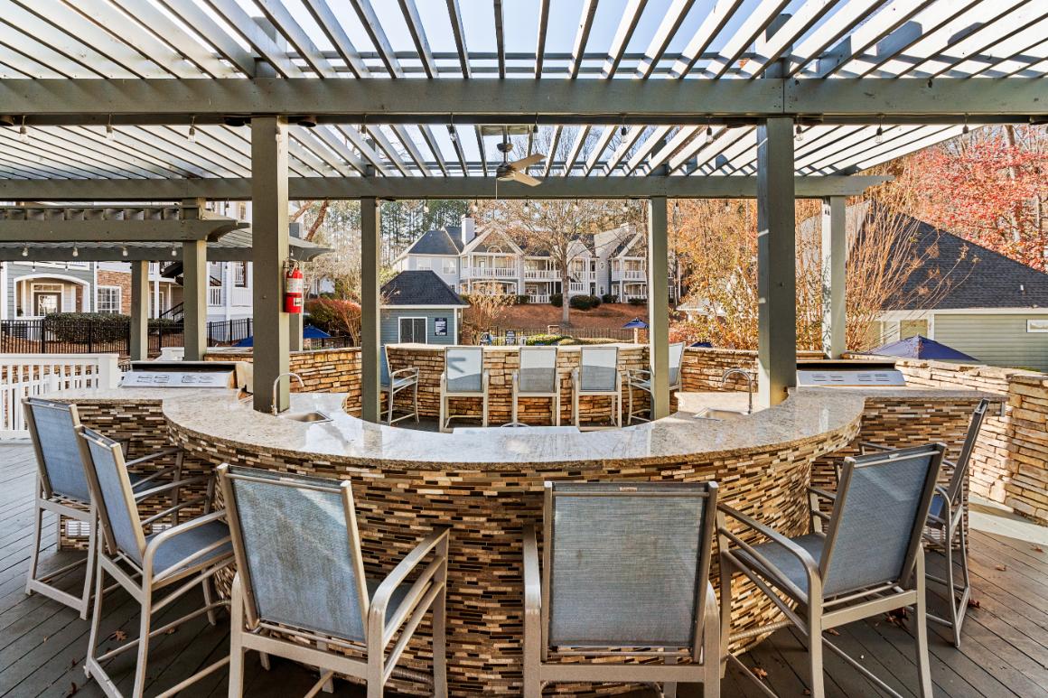 A patio with a table and chairs under a roof.