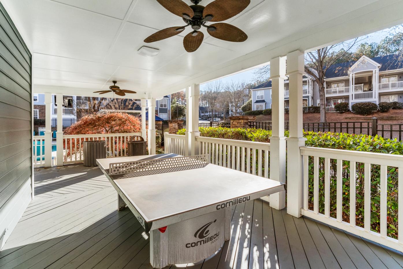 A white table tennis table is on a porch.