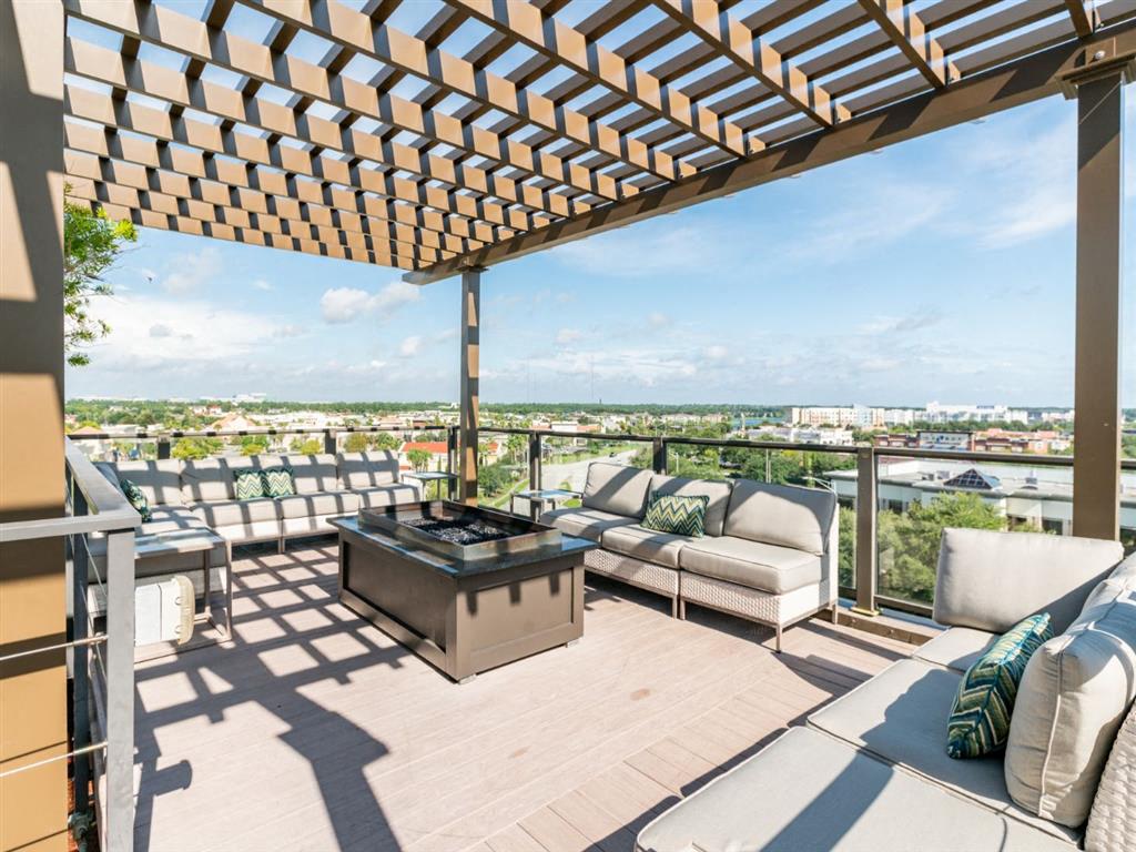 a covered patio with a fire pit and a view of the city