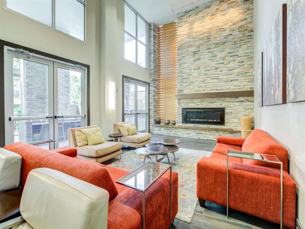 a living room with orange couches and chairs and a fireplace