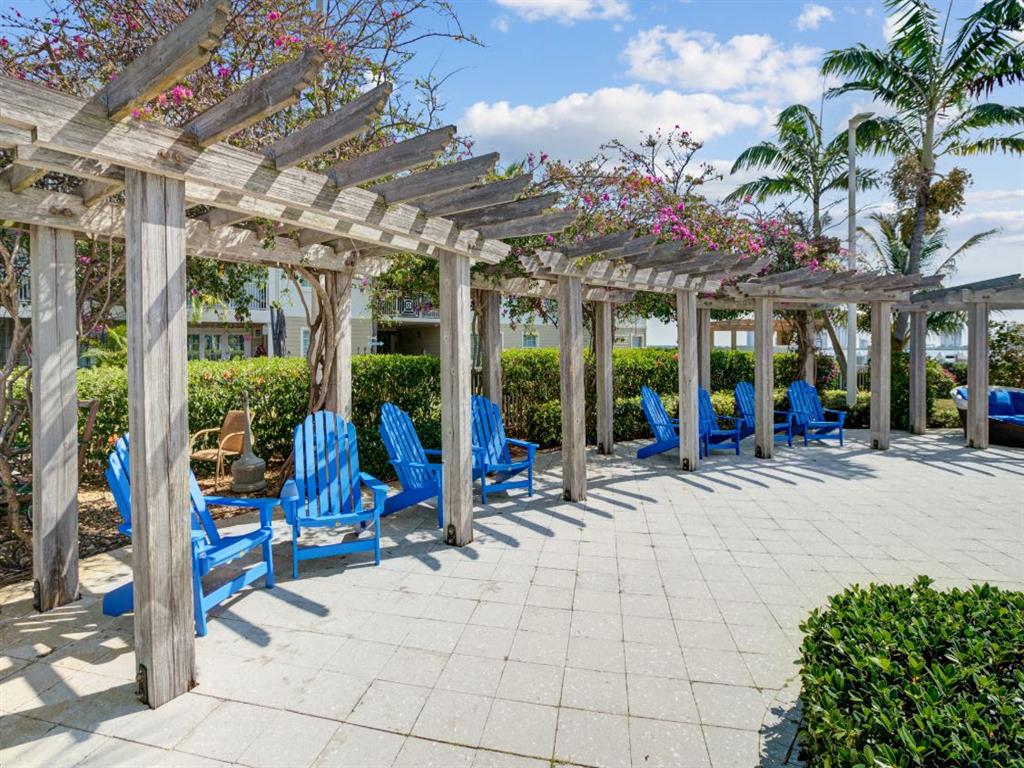 a group of blue chairs under a wooden pergola