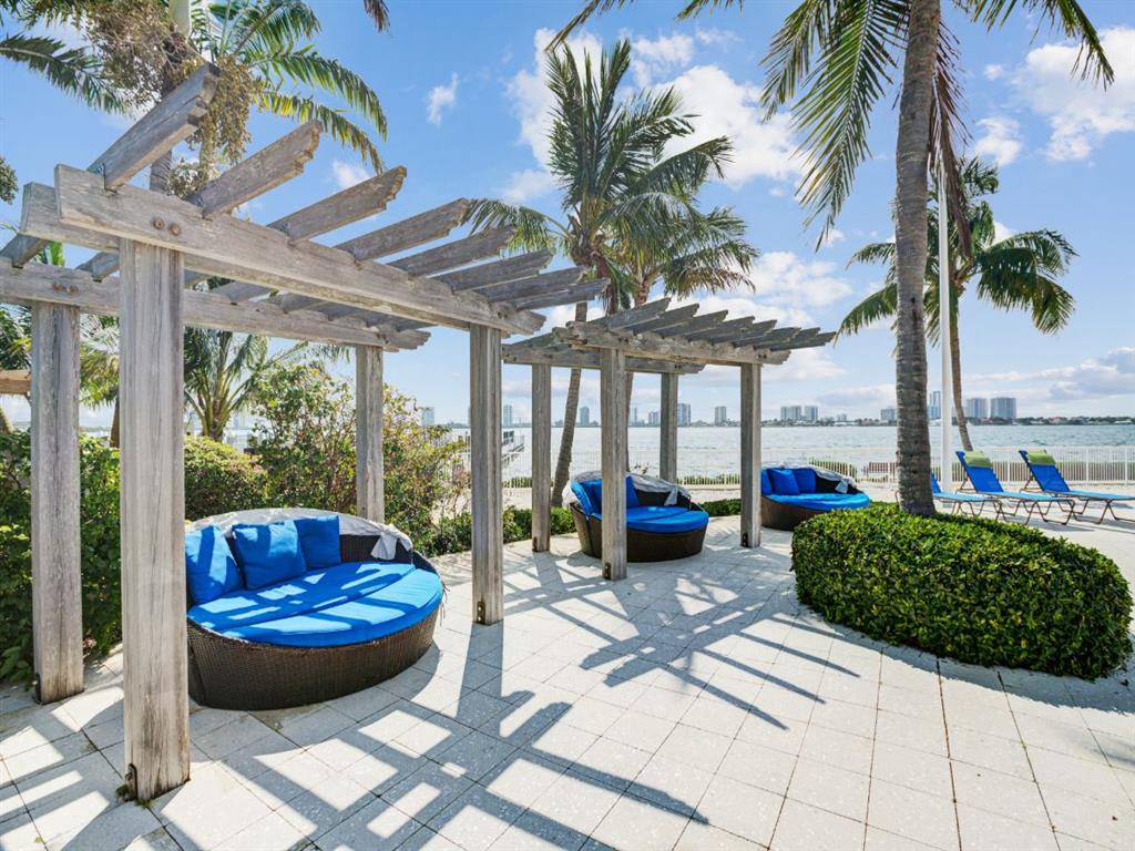 a patio with blue couches and a pergola