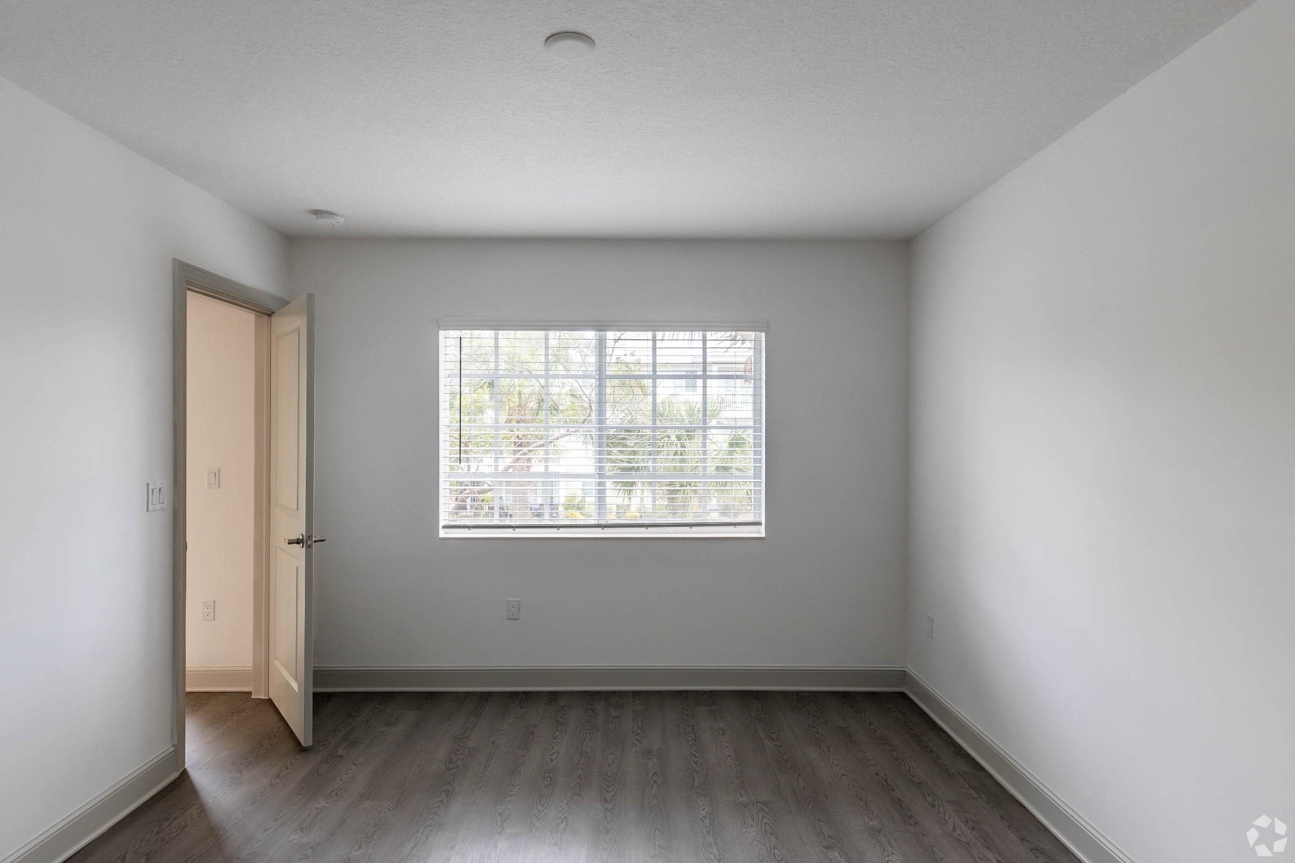 the living room of an empty house with a large window