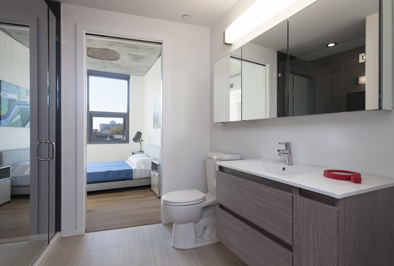 A modern bathroom with a toilet, sink, and mirror.