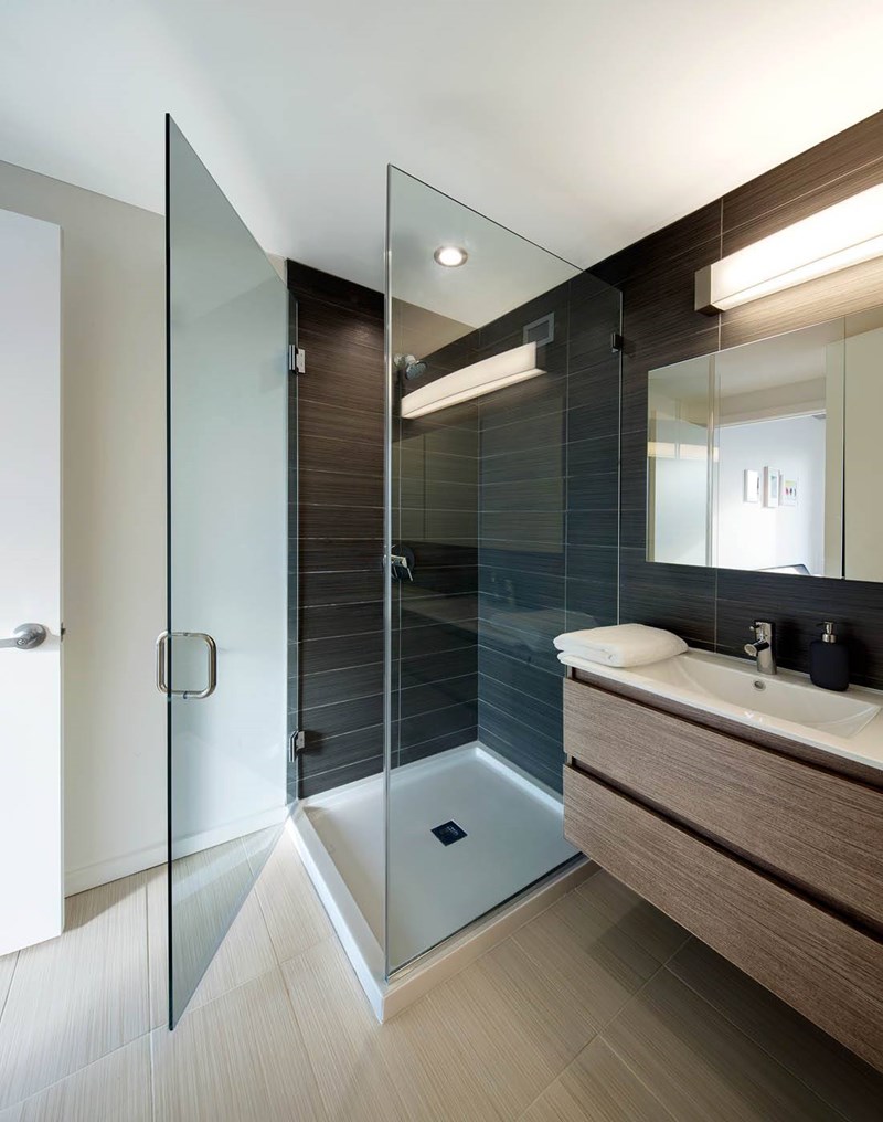 A modern bathroom with a walk-in shower and a sink vanity.