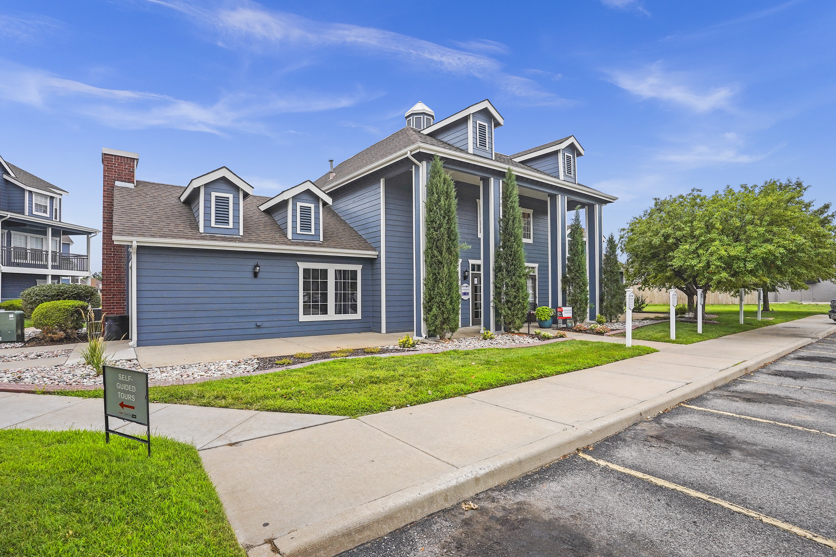 A row of townhouses with a sign in front of the first one.