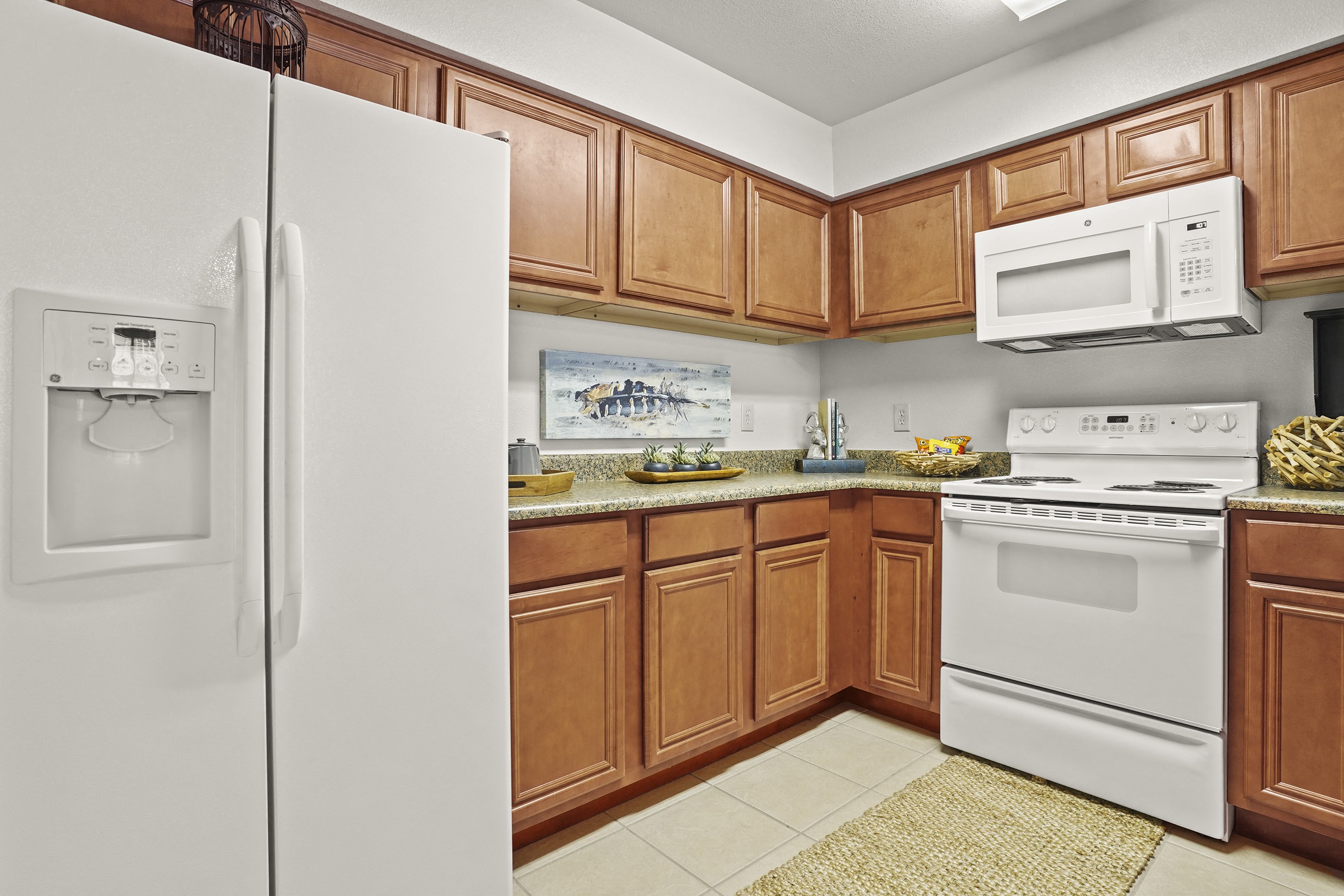 A kitchen with a white refrigerator and white stove.