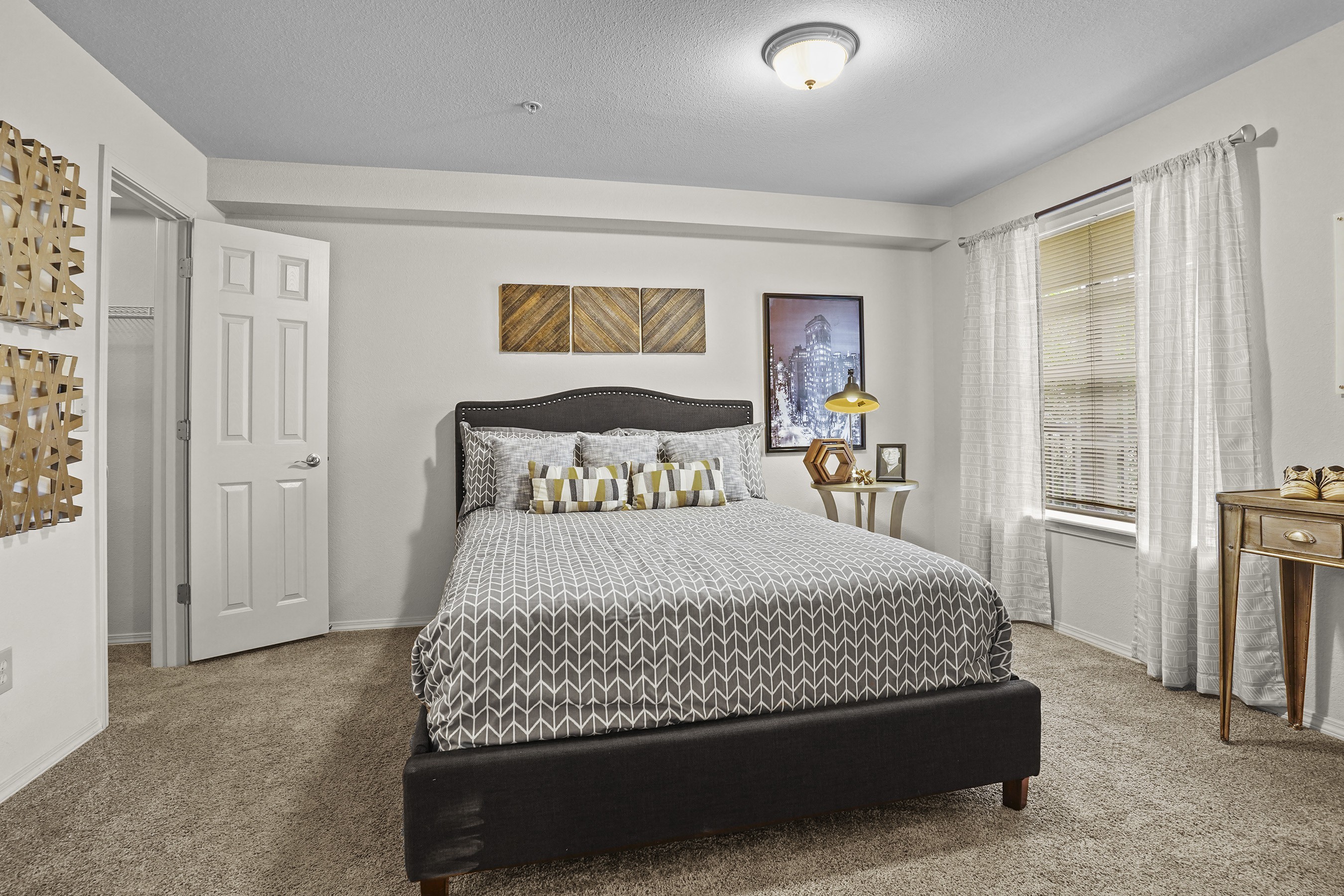 A bedroom with a large bed and a painting on the wall.