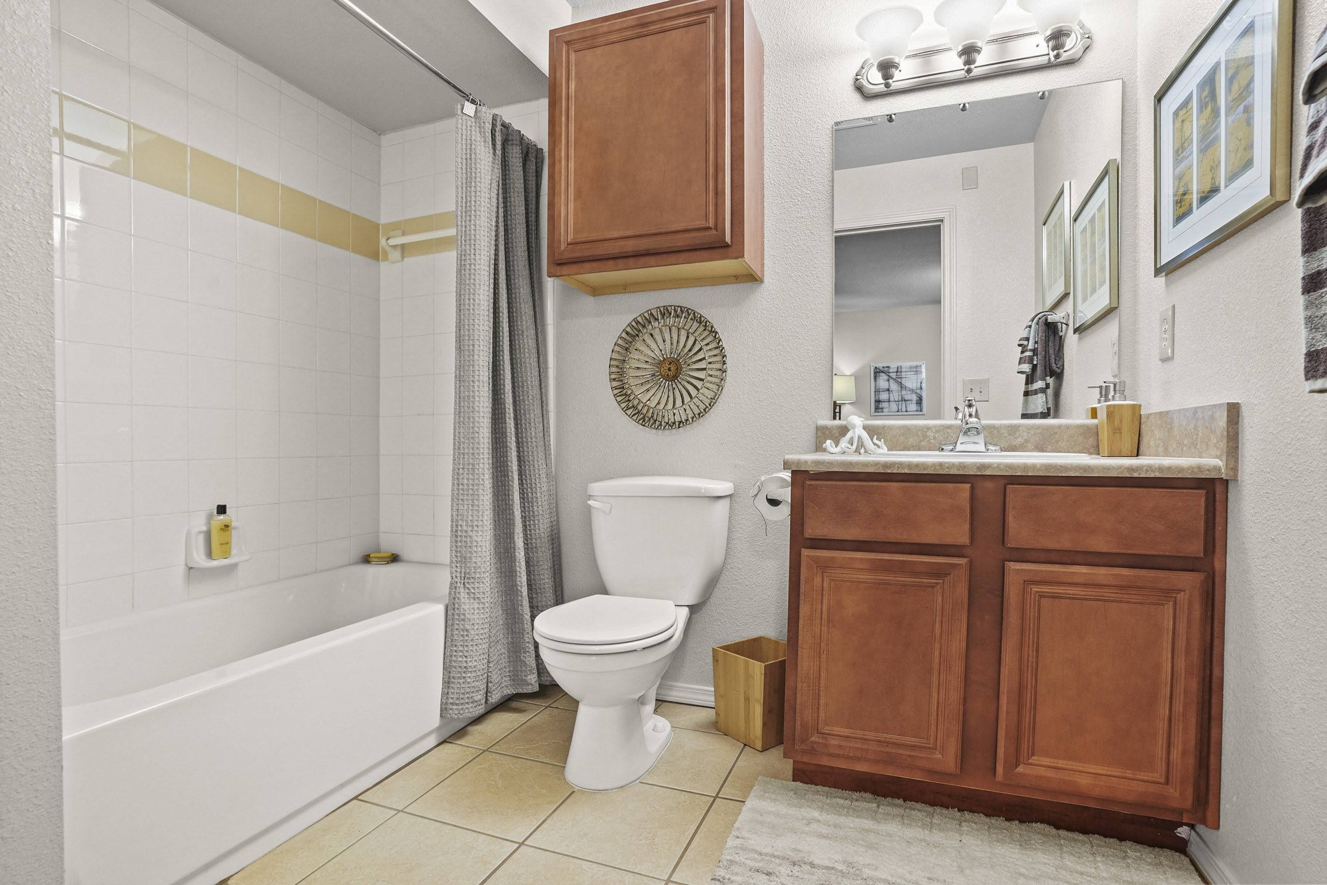 A white toilet sits next to a white bathtub in a bathroom.