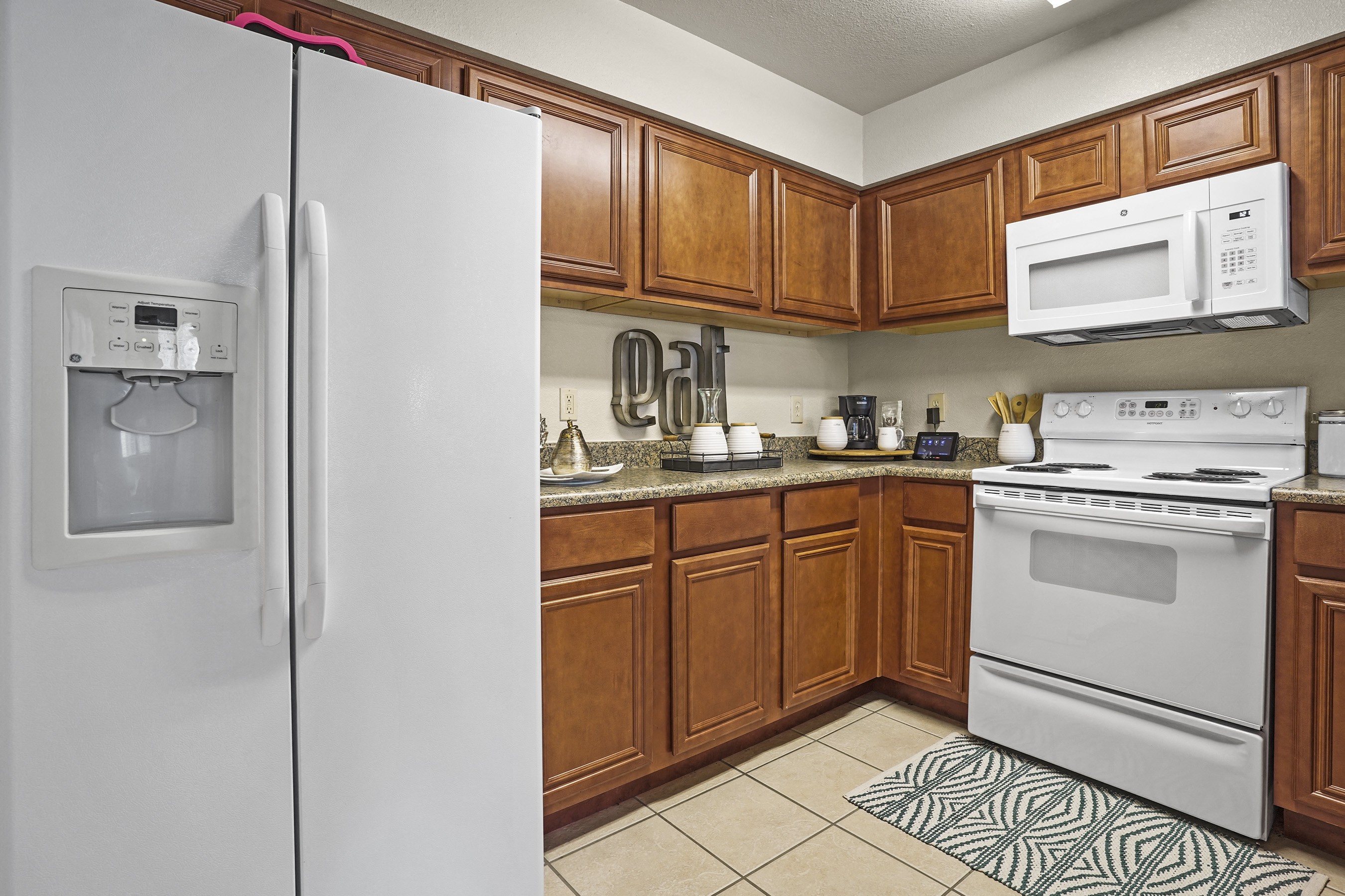 A kitchen with a white refrigerator and white oven.