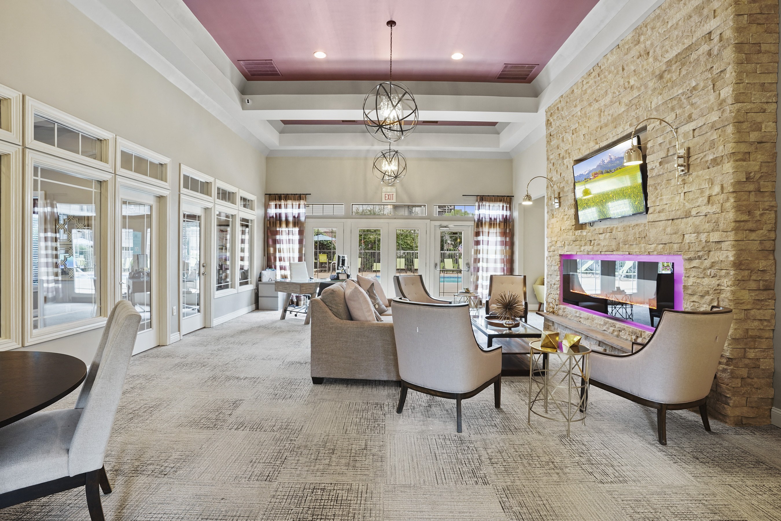 A modern living room with a stone wall and a flat screen TV.