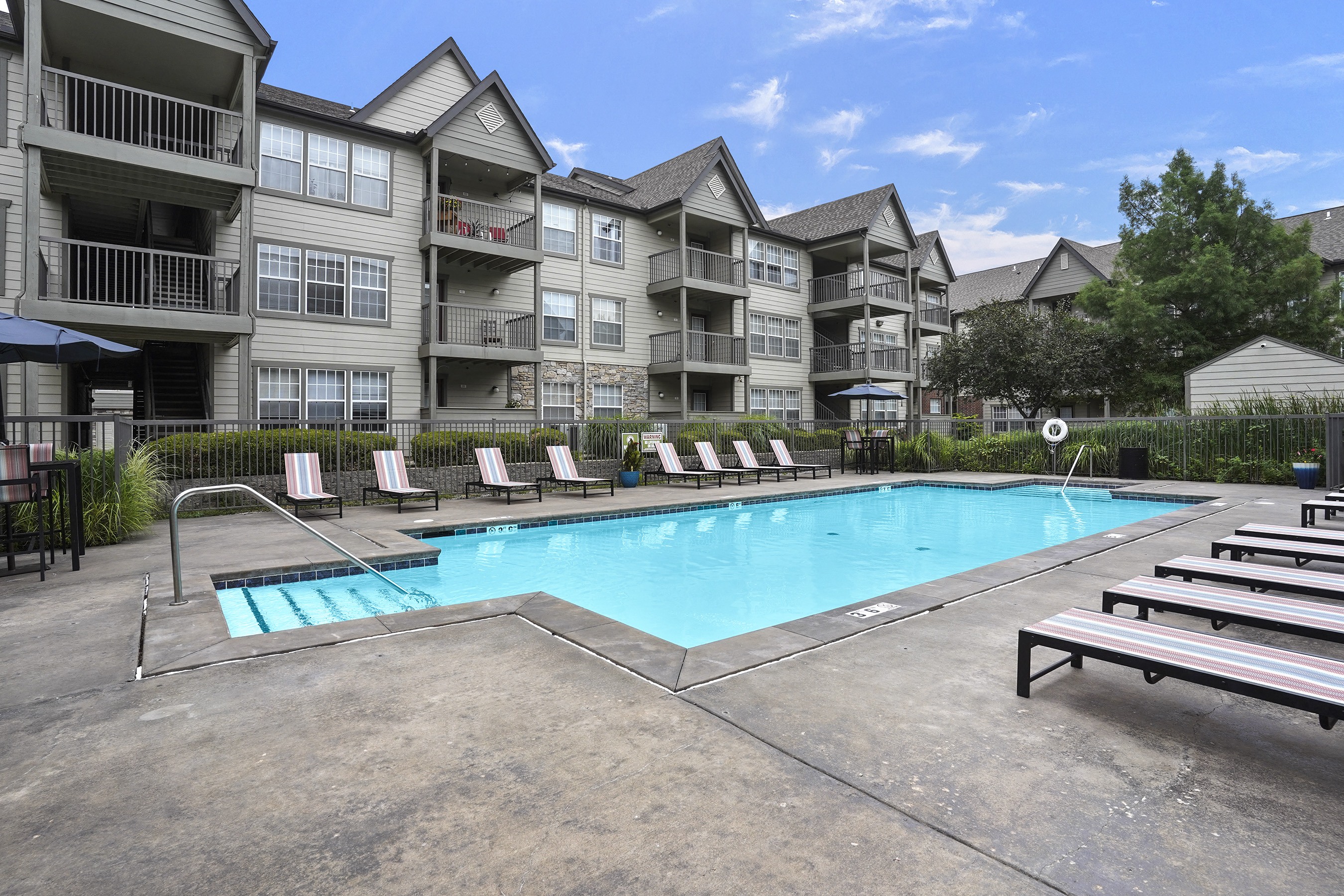 A swimming pool in front of apartment buildings.