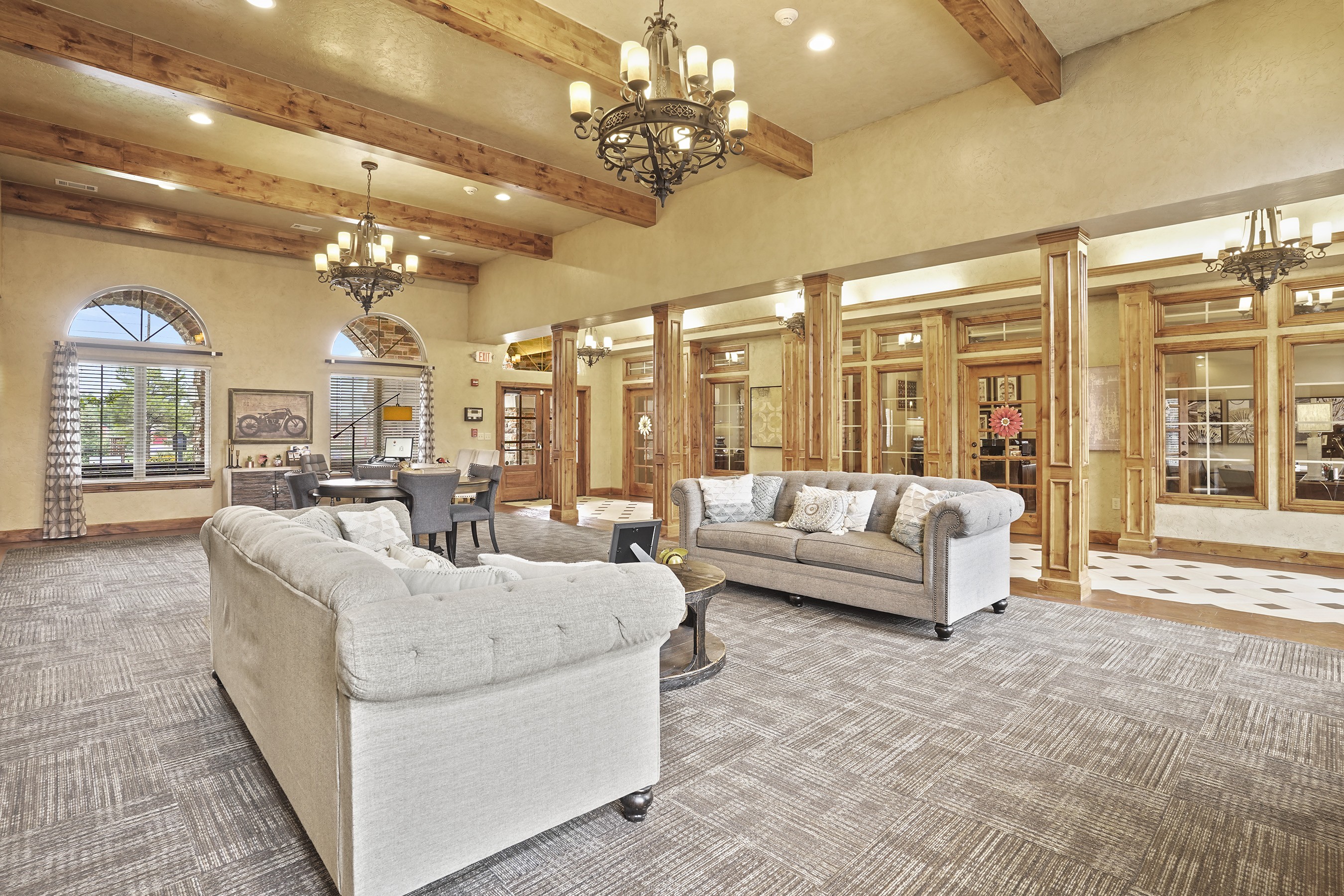 A large, well-lit room with a couch, a chair, and a coffee table.