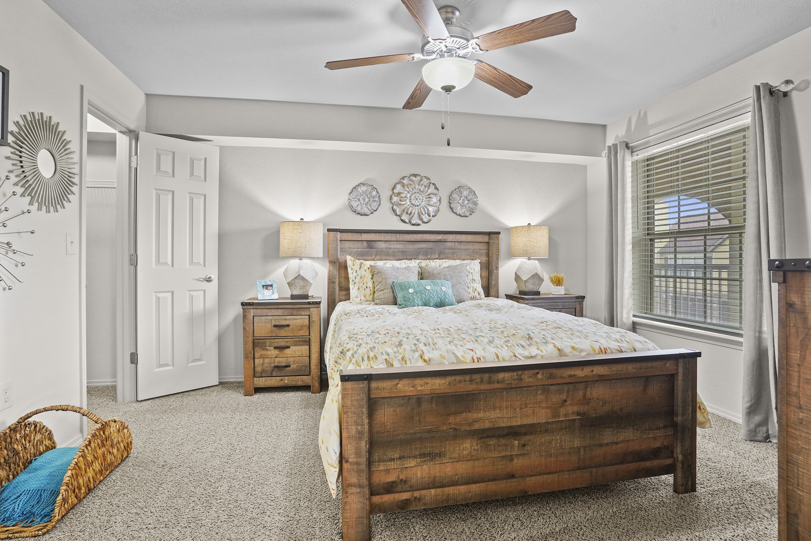 A bedroom with a bed, nightstand, and a ceiling fan.
