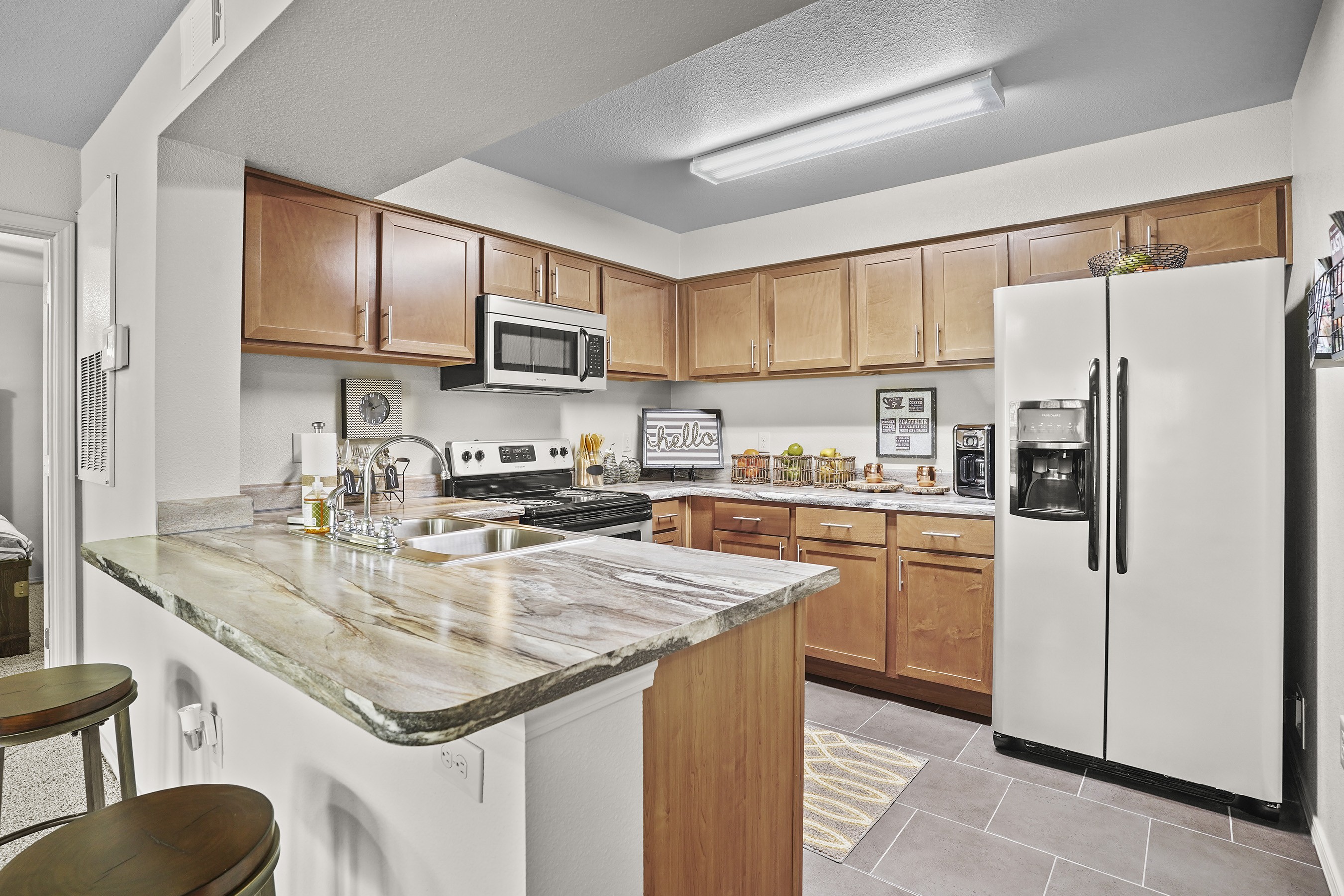 A kitchen with a marble countertop and white appliances.