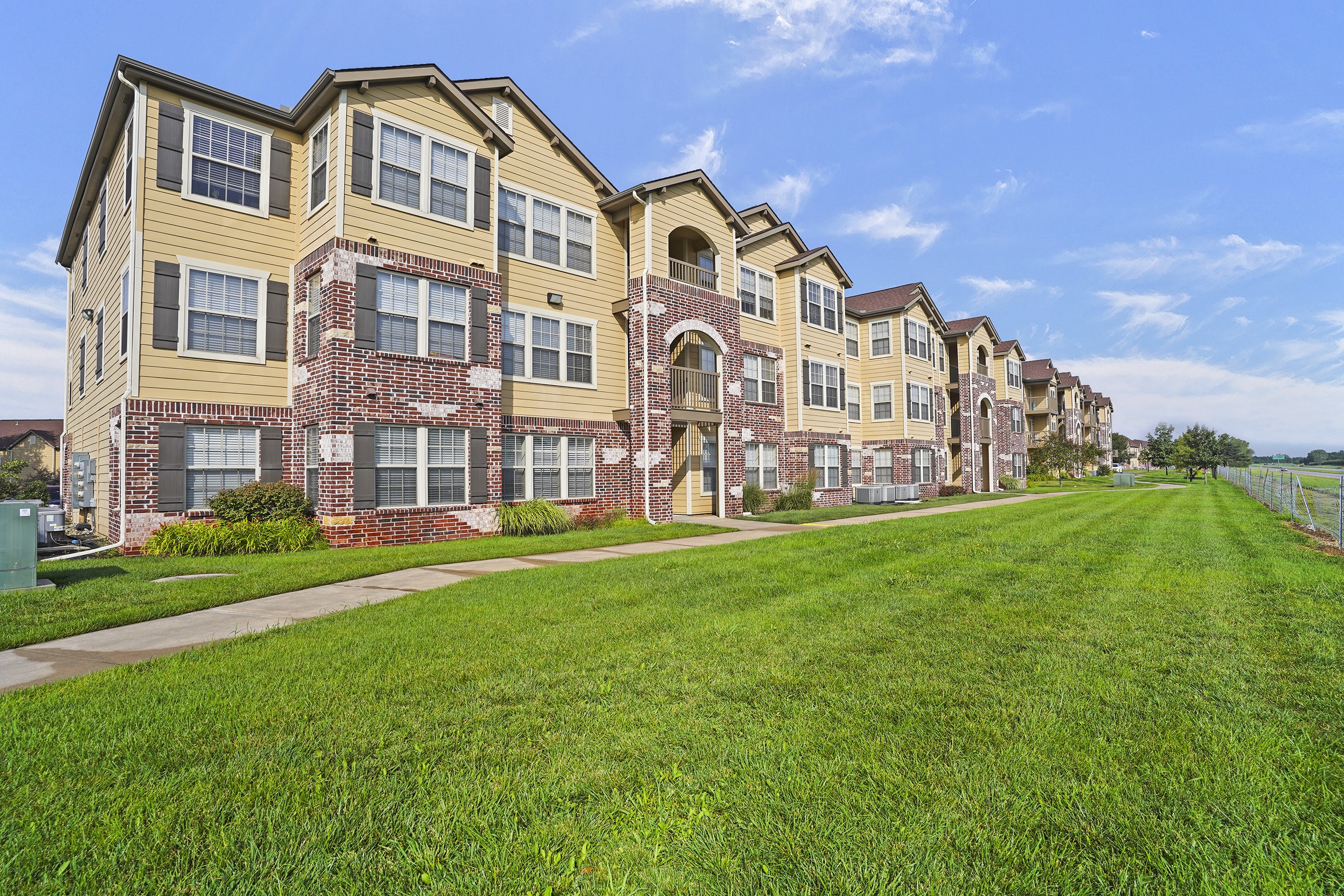 A long building with a green lawn in front.