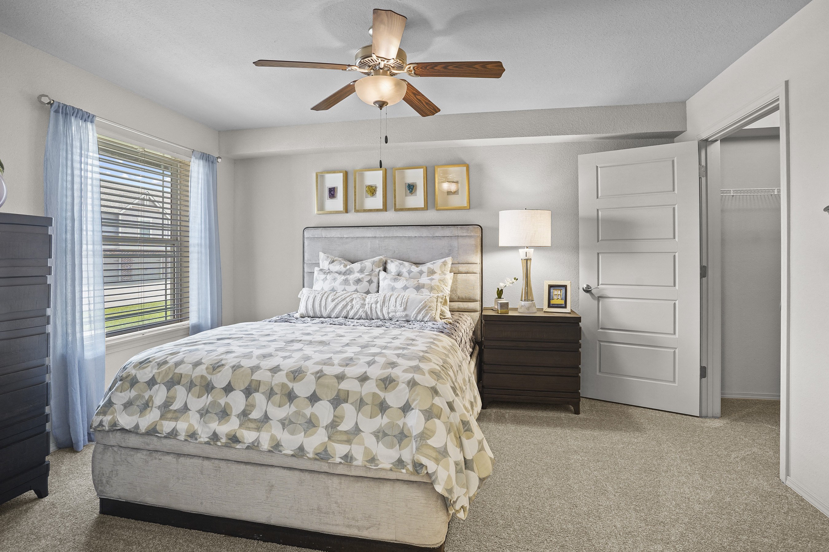 A bedroom with a large bed and a ceiling fan.