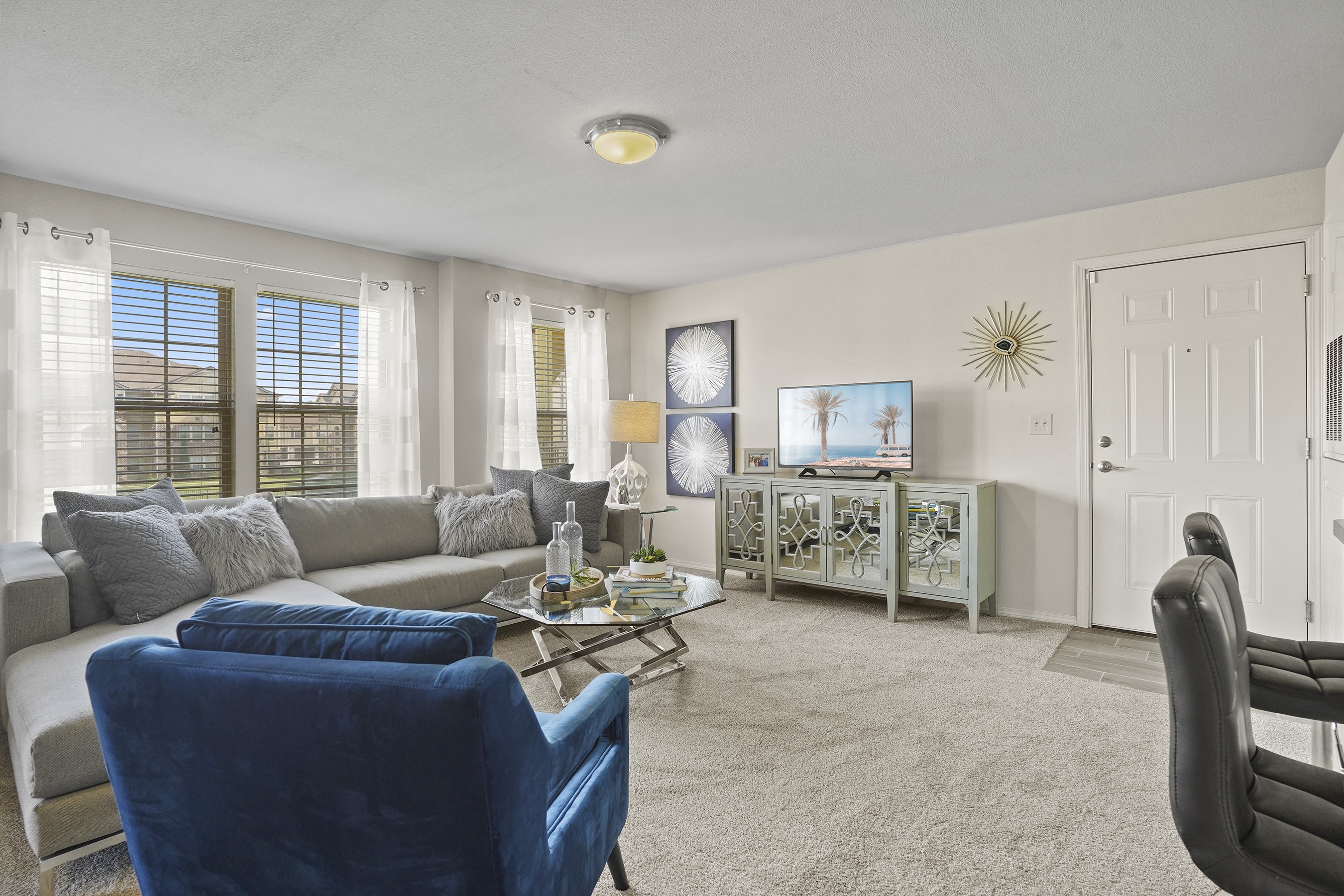 A living room with a grey couch, a blue chair, and a coffee table.