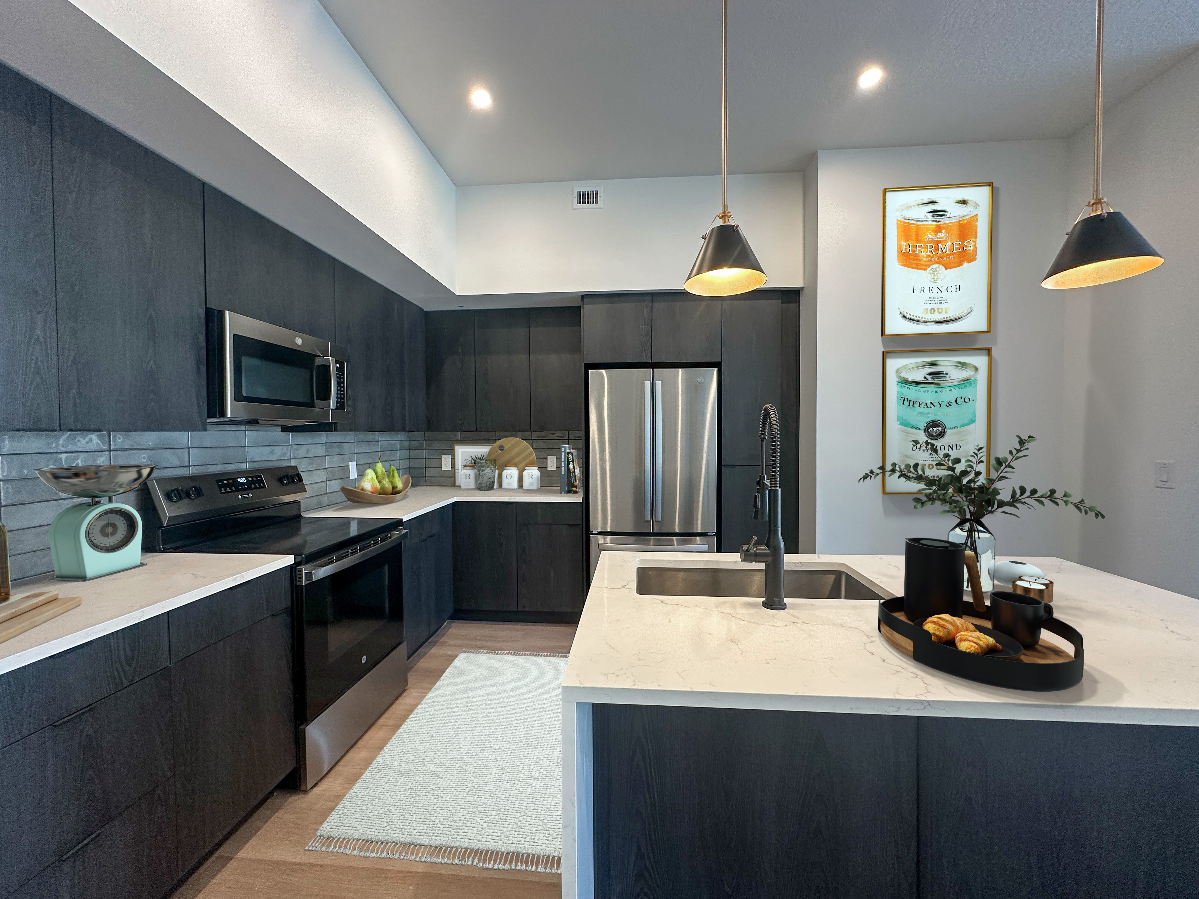Liberty Duet Apartments, Salt Lake City, Utah; A modern kitchen with dark wood cabinets and a white countertop, kitchen island, stainless steel appliances..
