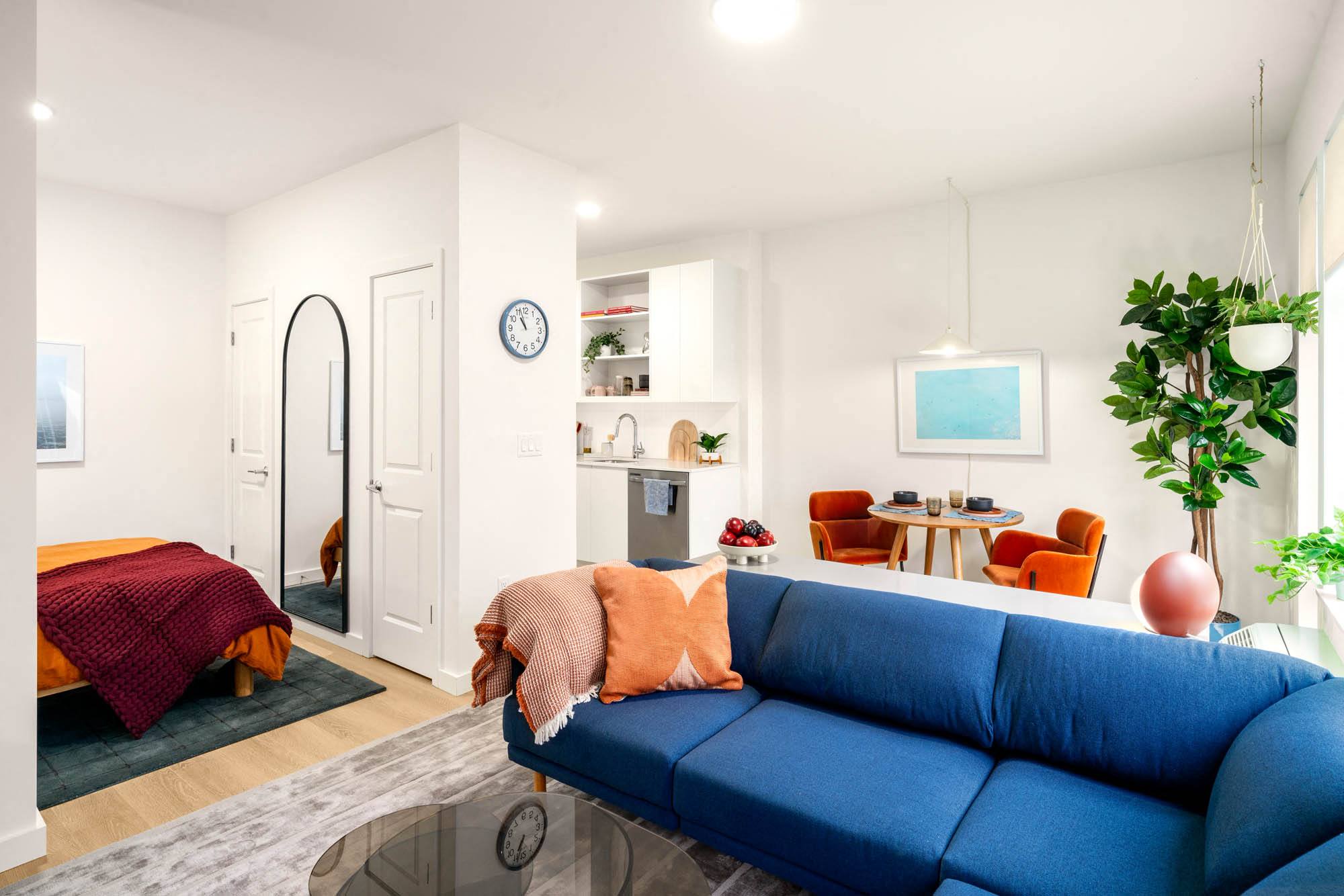 ,,a living room with a blue couch and a kitchen