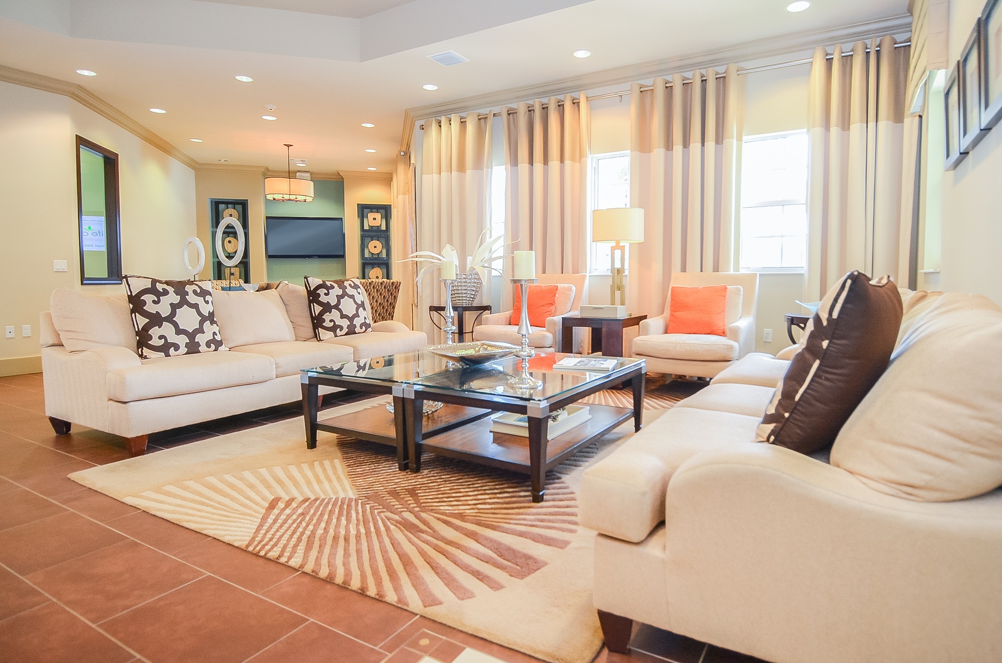 A living room with a white couch and a glass coffee table.