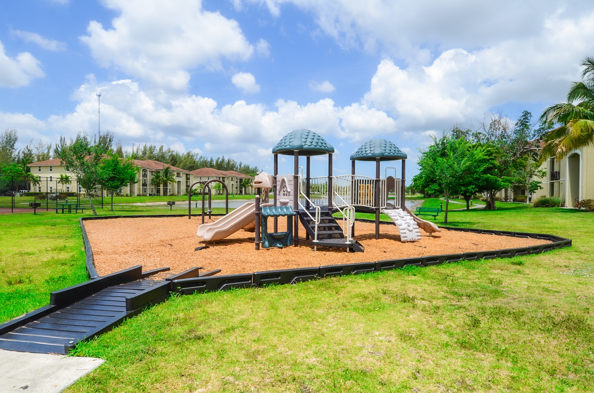 A playground with a slide, swings, and a gazebo.
