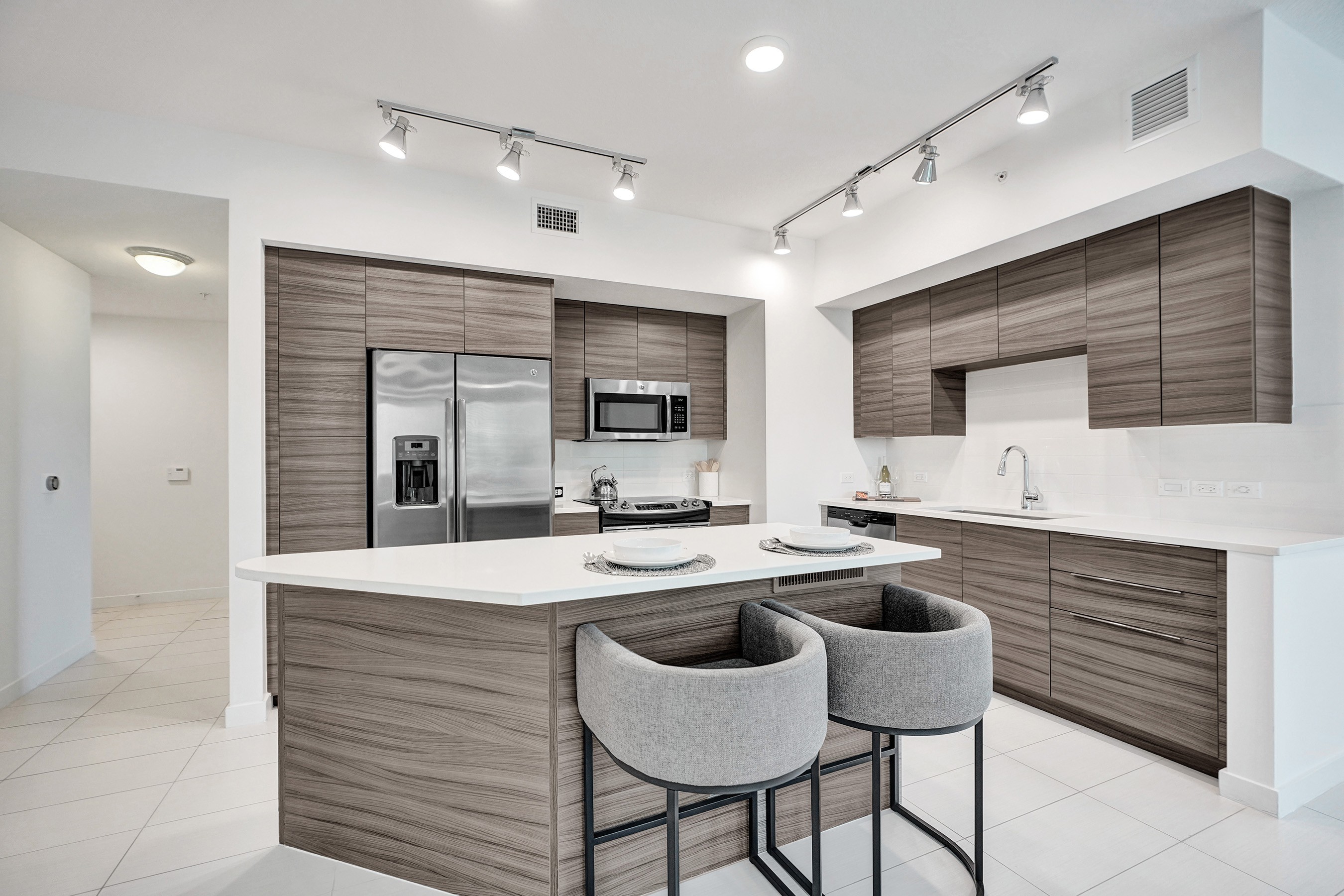 A modern kitchen with a white countertop and brown cabinets.