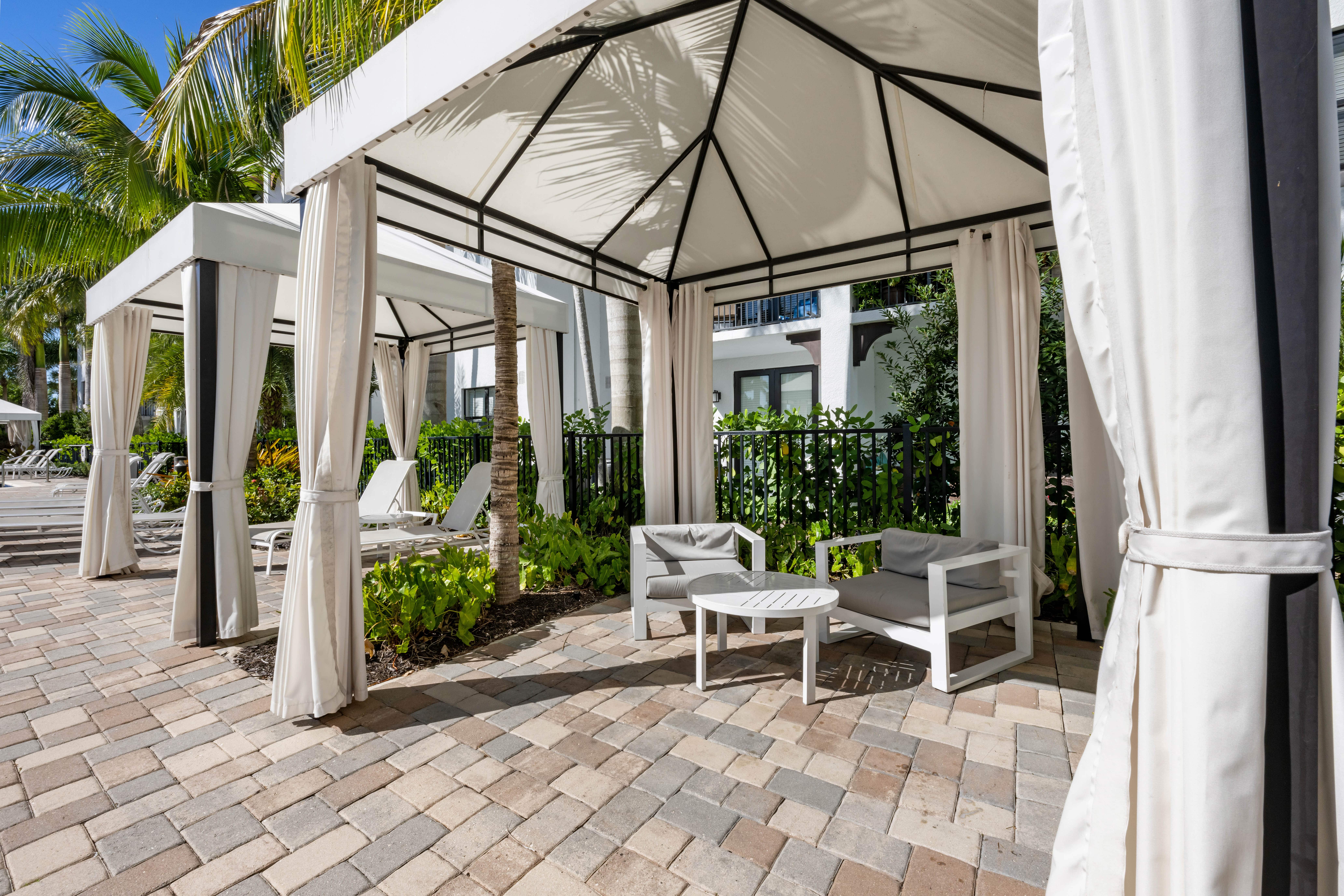 A patio with a white canopy and chairs.