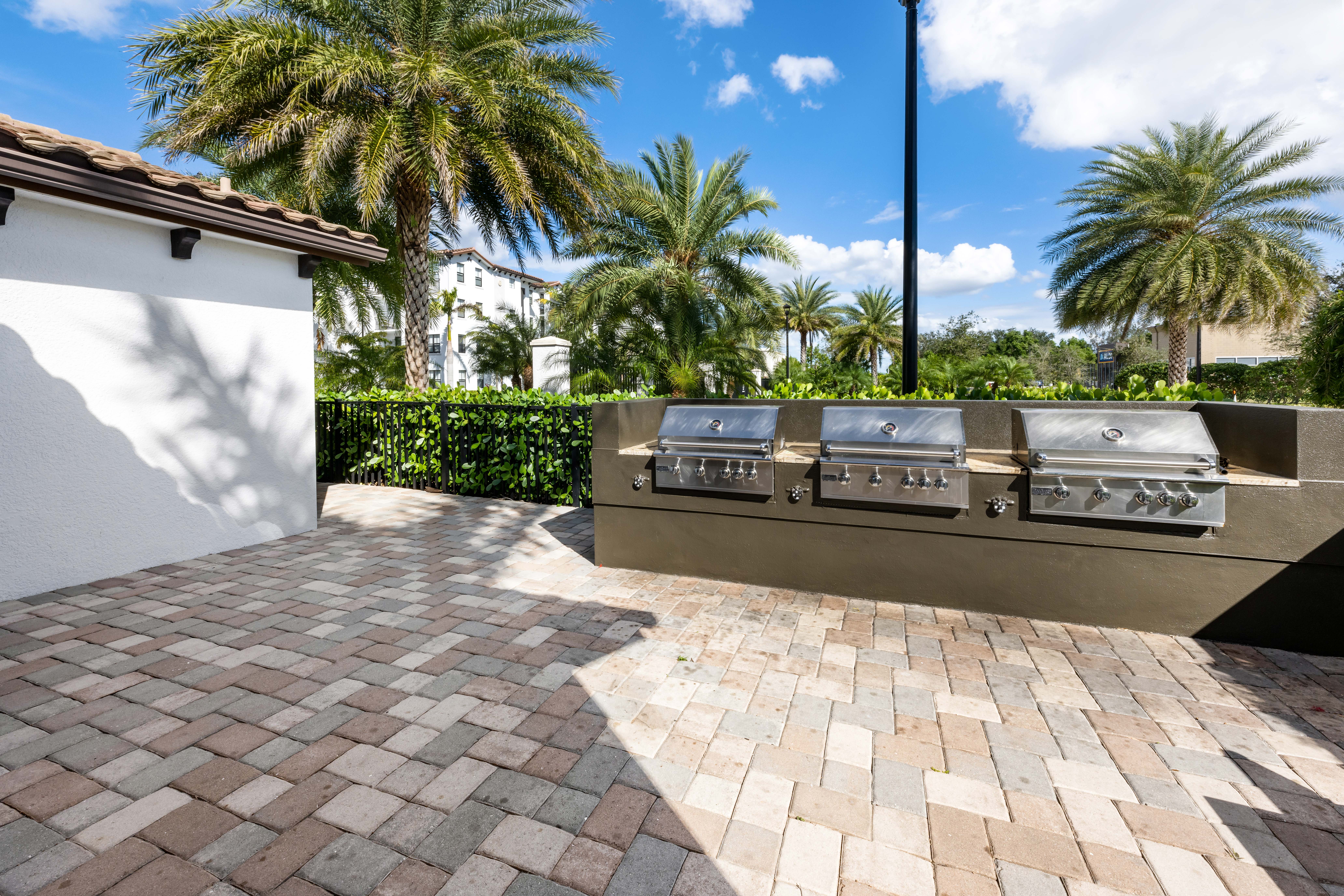 A row of grills are on a patio.
