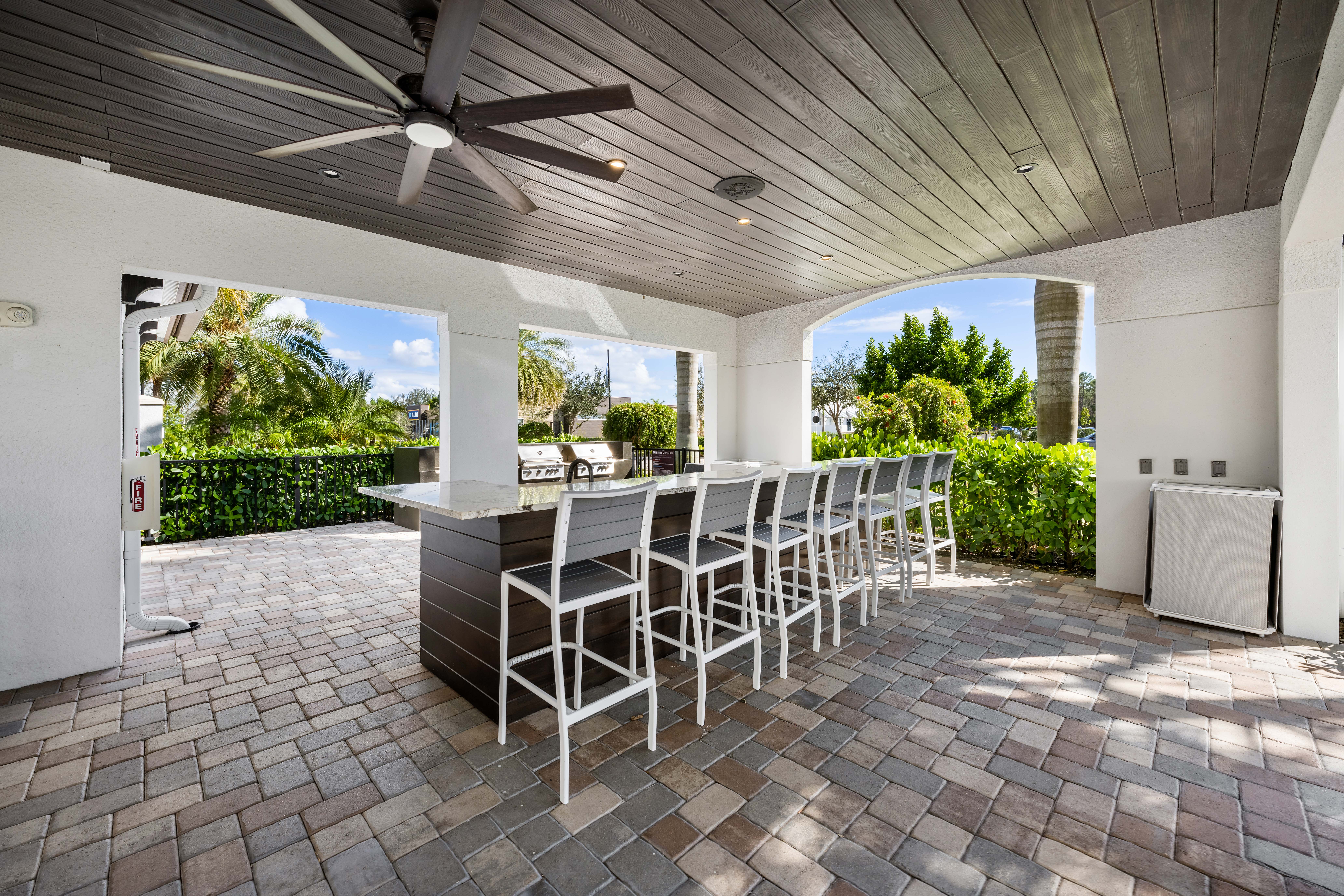 A patio with a table and chairs is covered by a roof.