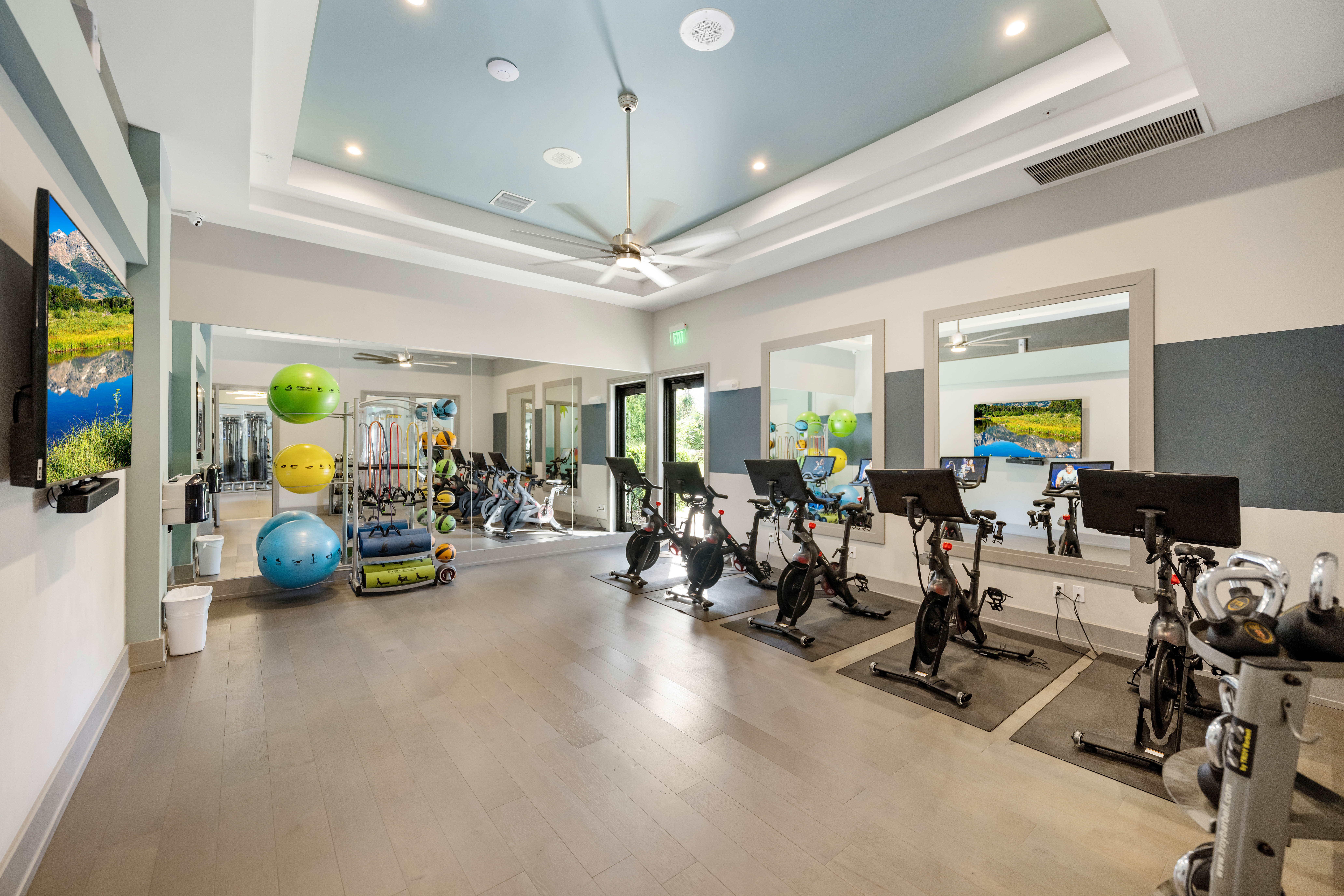 A spacious gym with exercise equipment and a view of the outdoors.