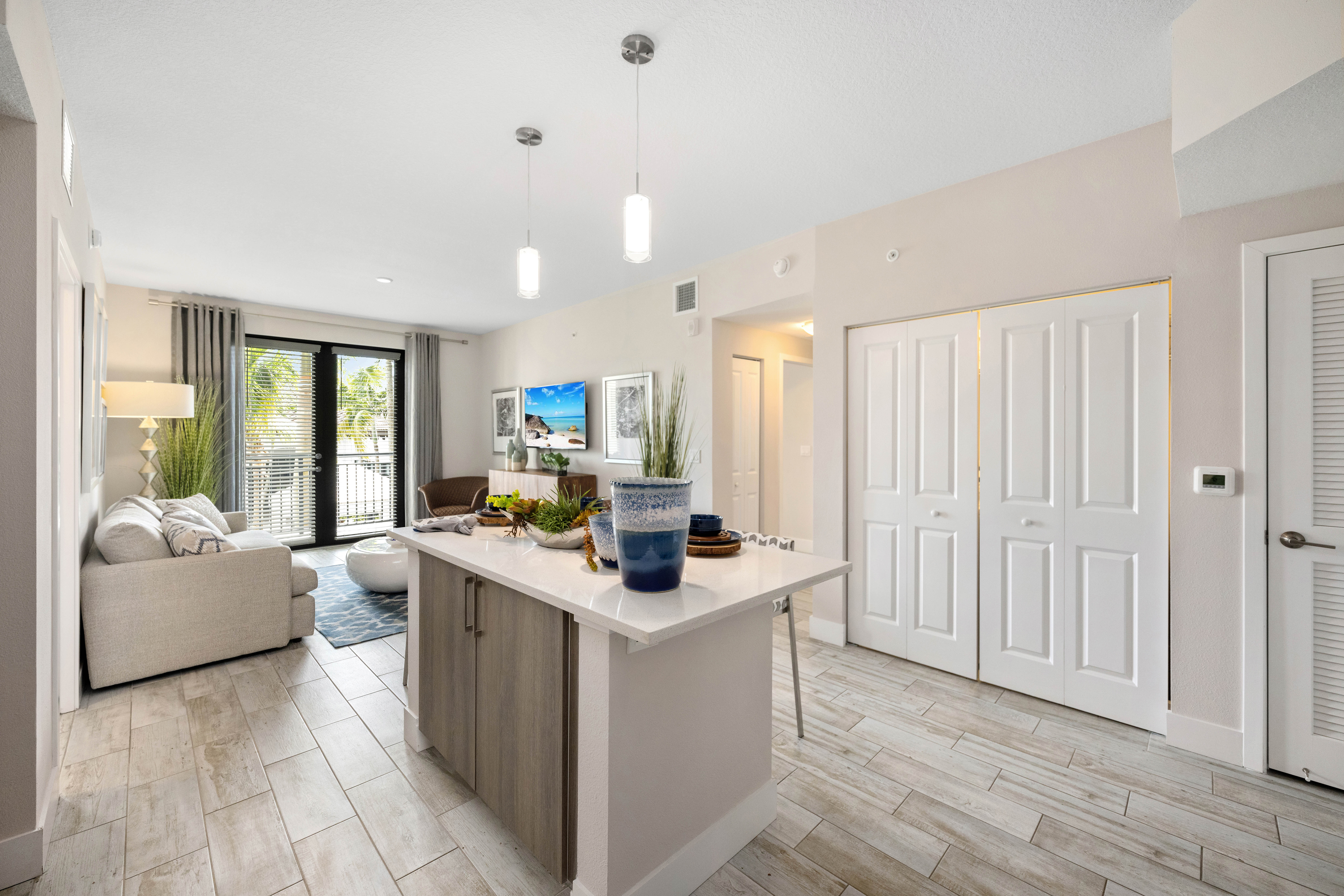 A modern kitchen with a large island and a couch with pillows.