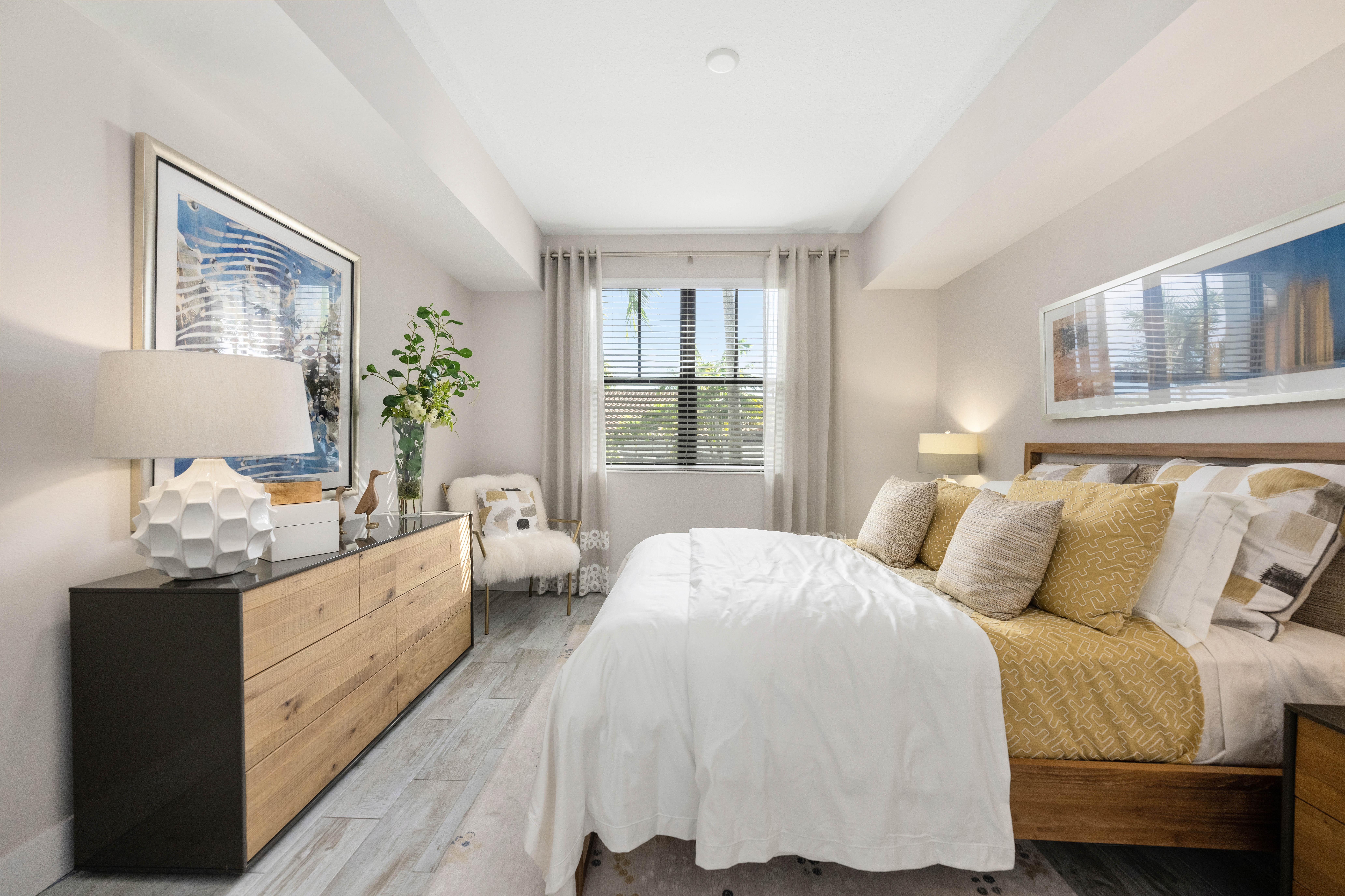 A bedroom with a large bed and a wooden dresser.