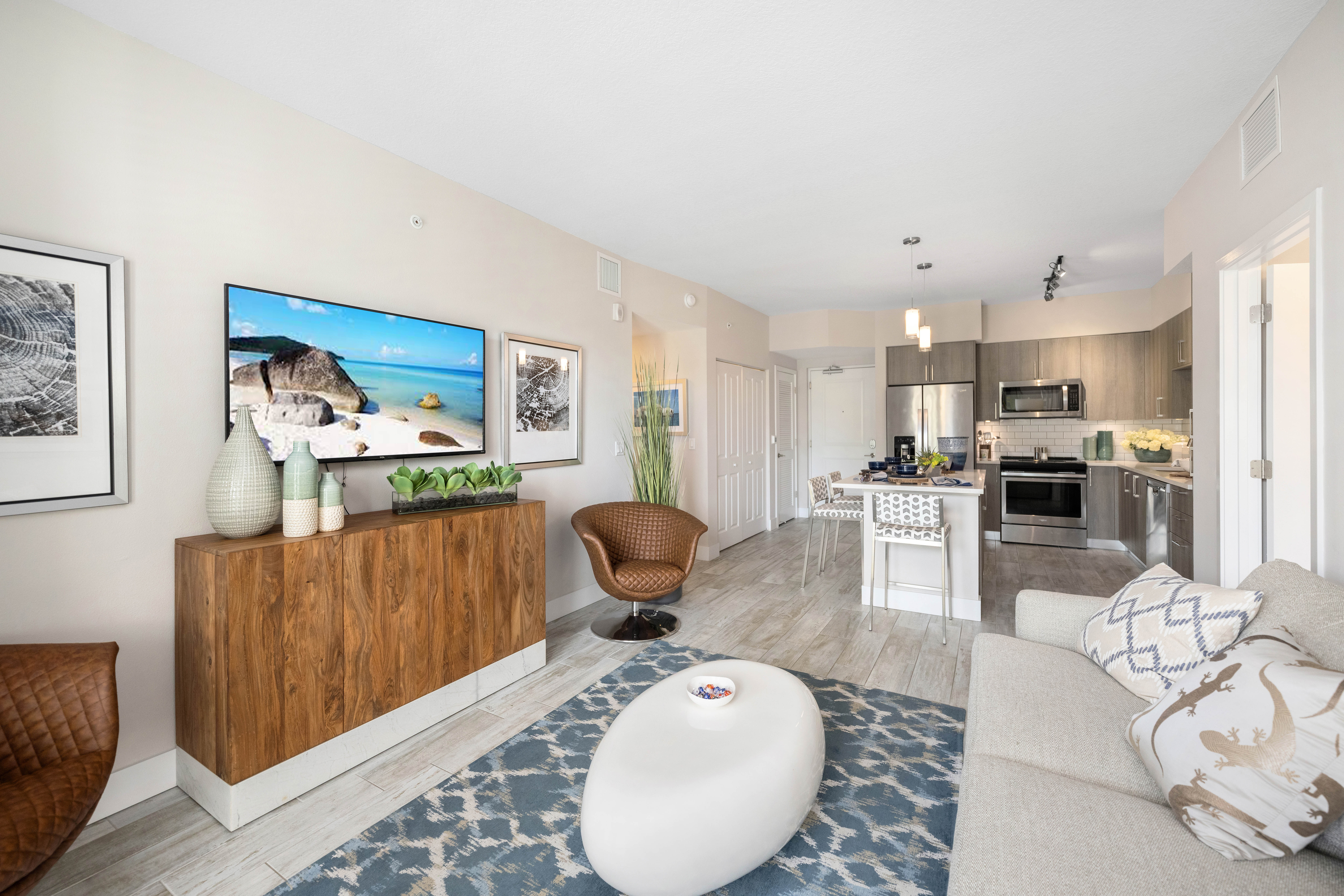 A modern living room with a wooden cabinet and a large painting on the wall.