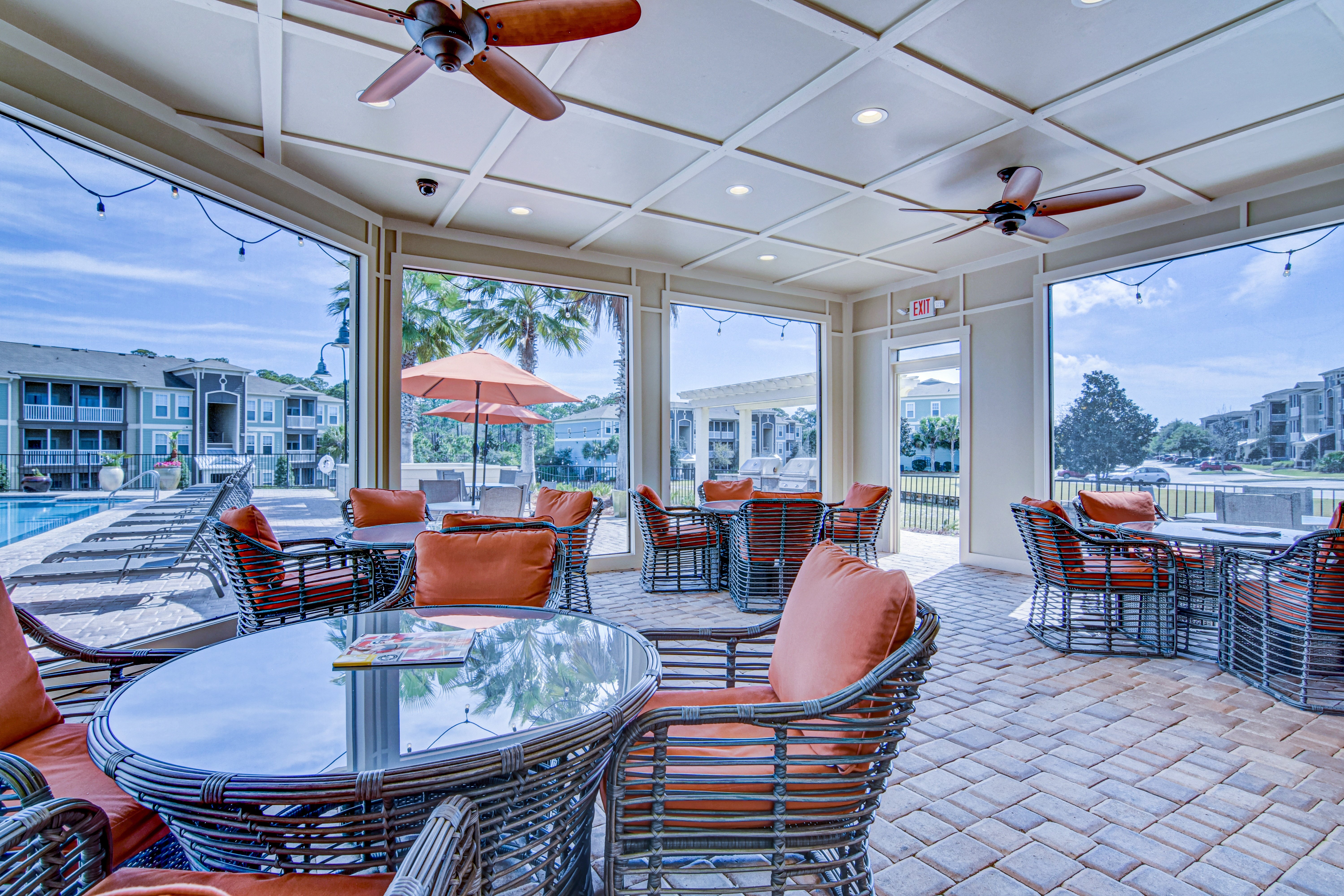 A patio with a table and chairs and a ceiling fan.