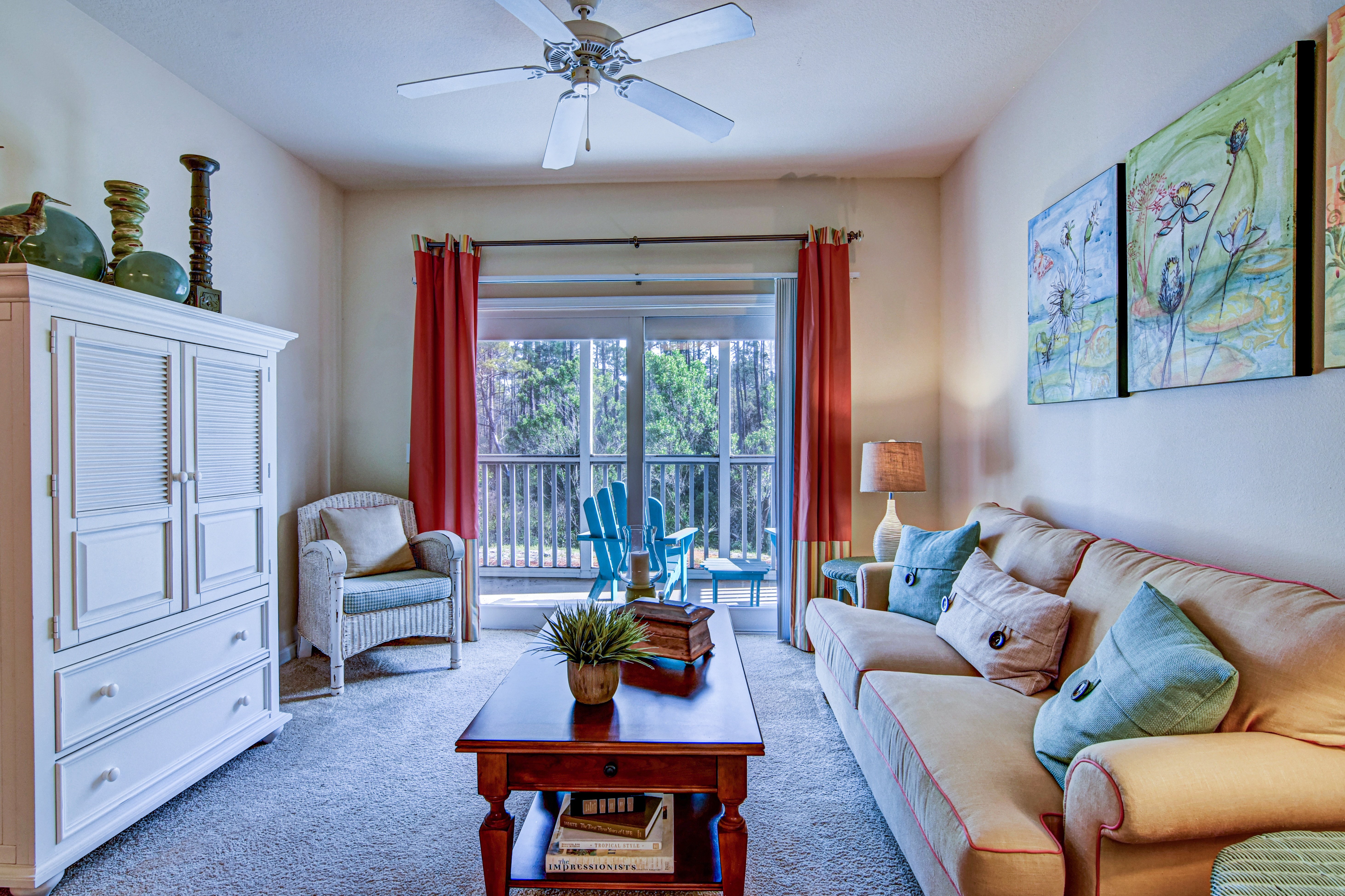 A living room with a couch, a chair, a table, and a ceiling fan.