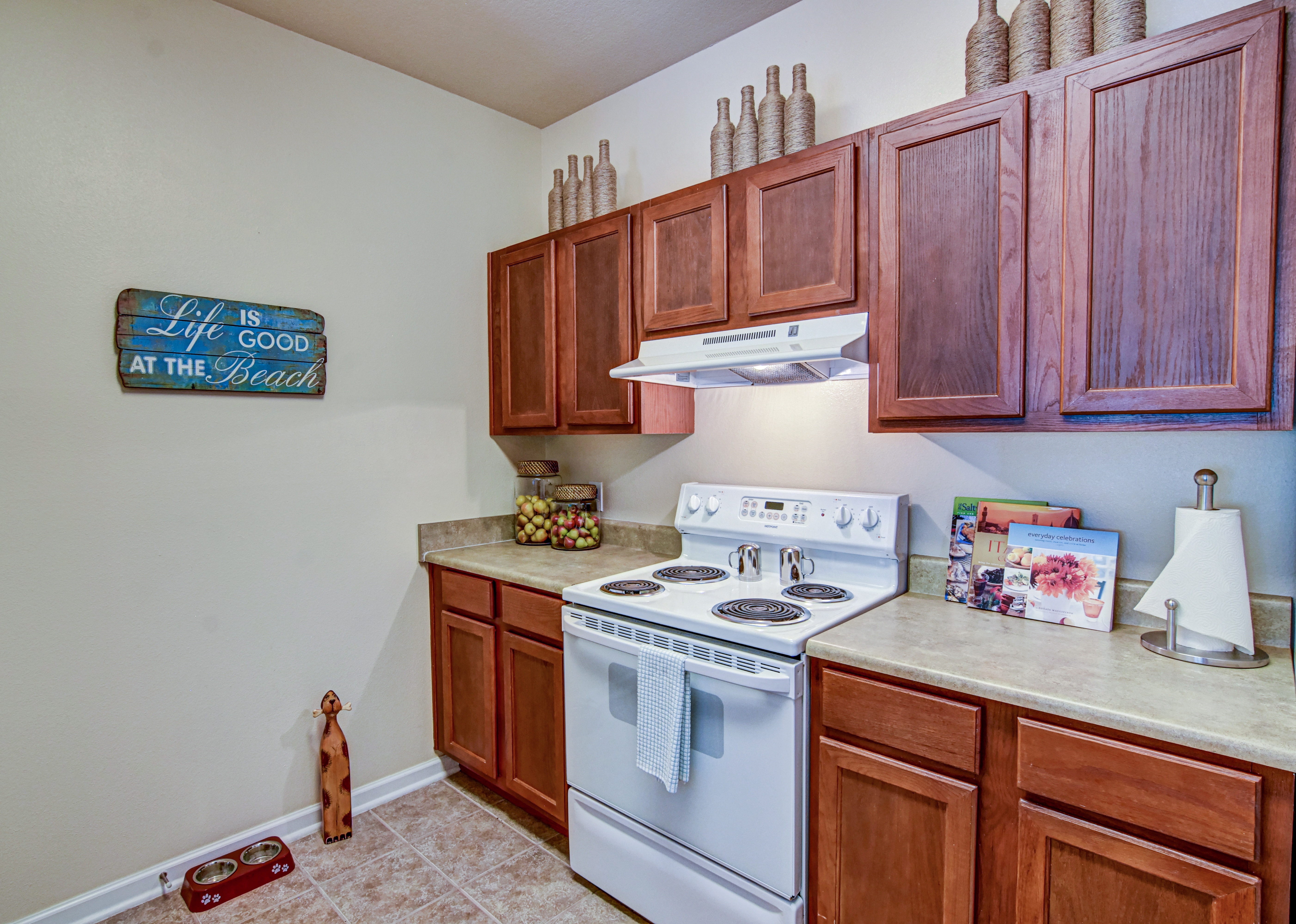 A kitchen with a white stove and wooden cabinets.
