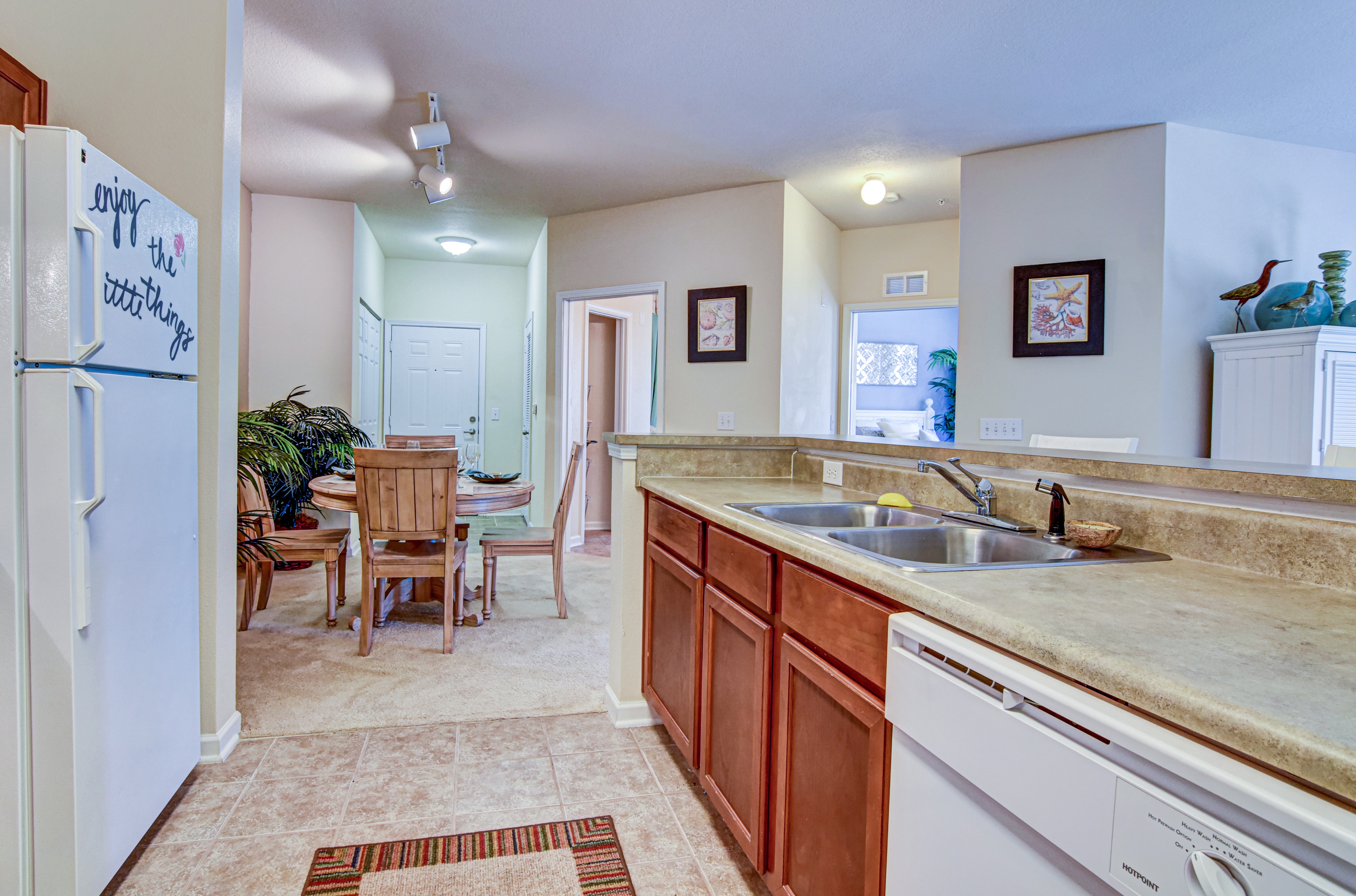 A kitchen with a white fridge and brown cabinets.