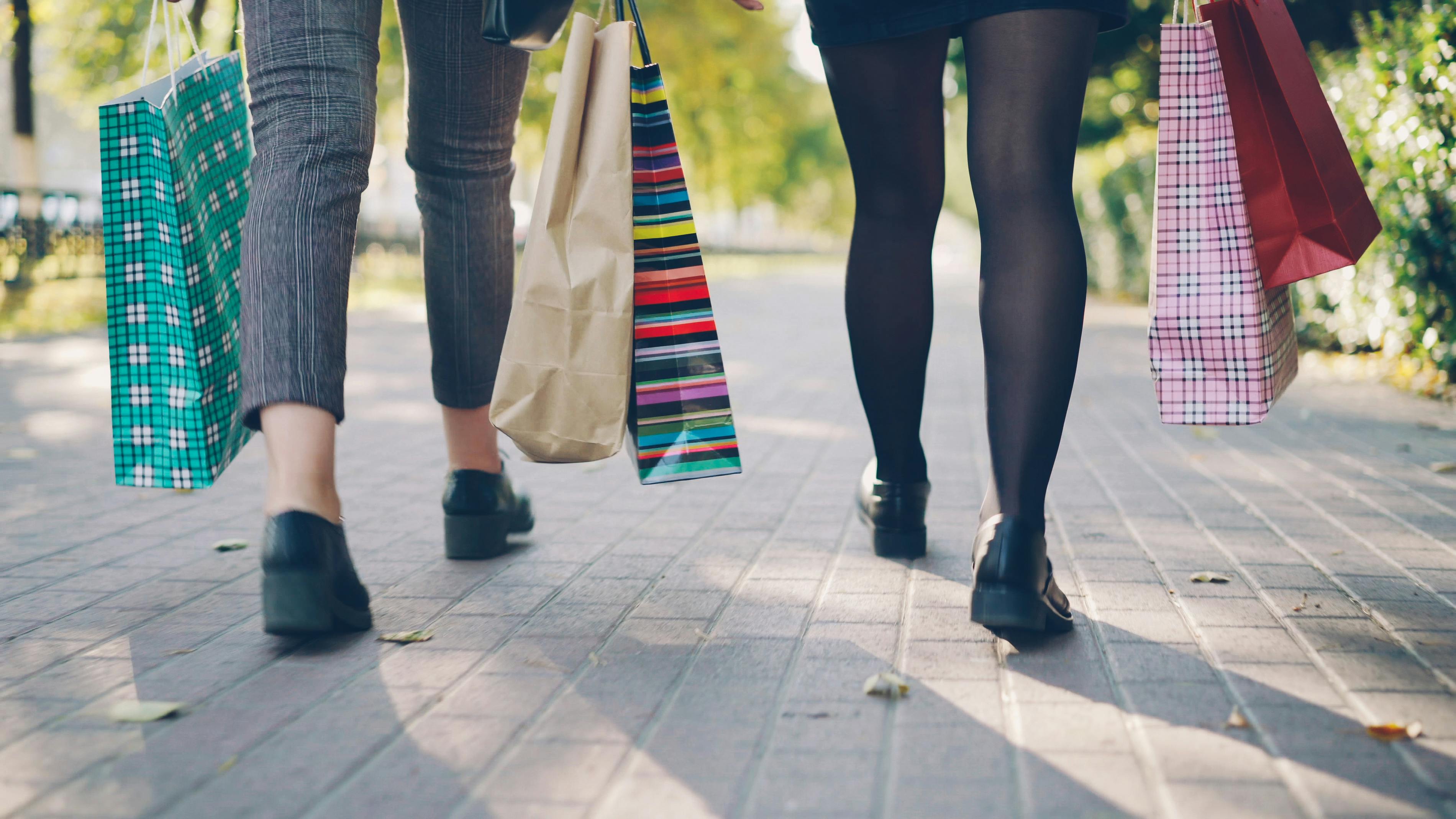 Three people walking with shopping bags.