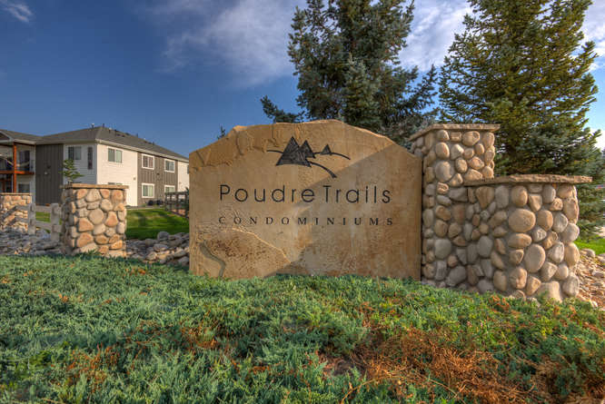 a stone sign that says poudre trails condominiums