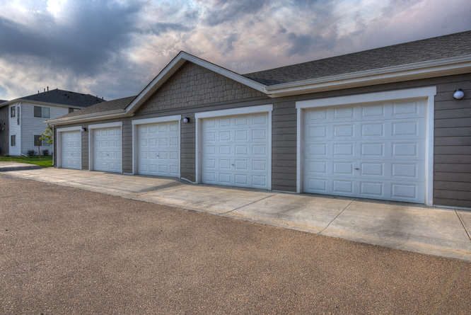 a row of garages with a cloudy sky in the background