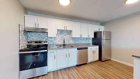 A kitchen with white cabinets and a black stove top oven.