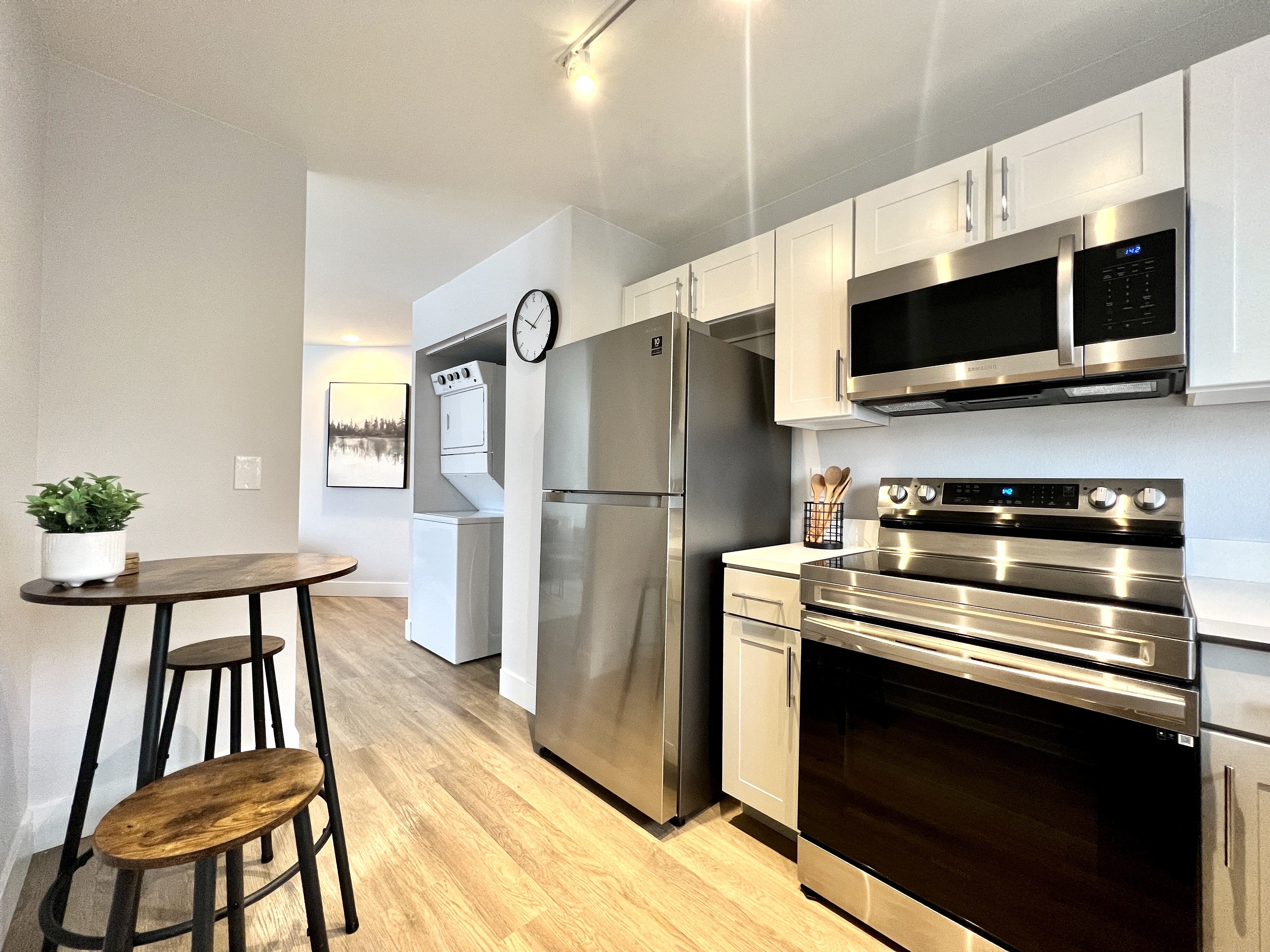 a kitchen with stainless steel appliances and a table with a stool