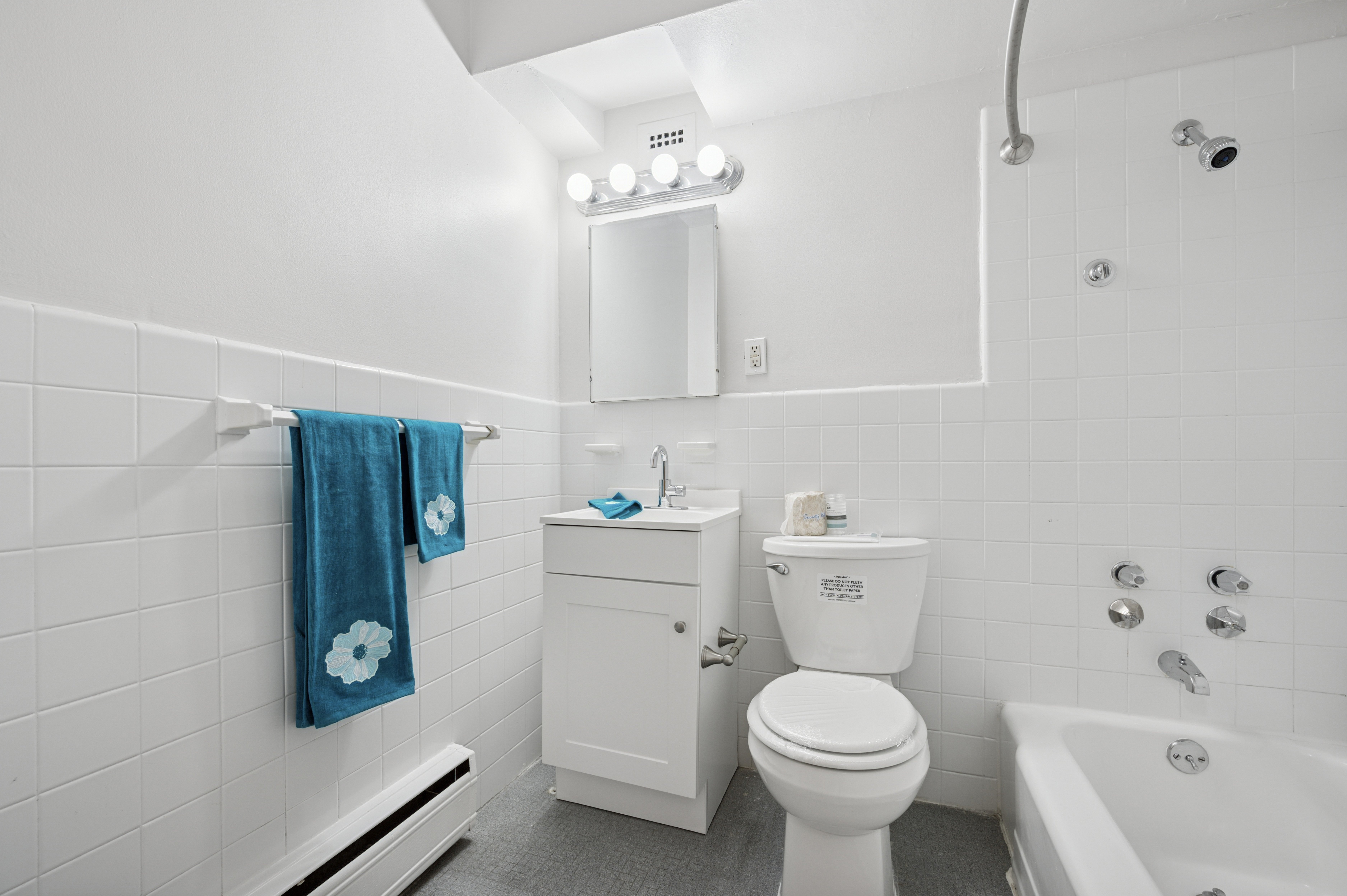 A white bathroom with a toilet, sink, and bathtub.