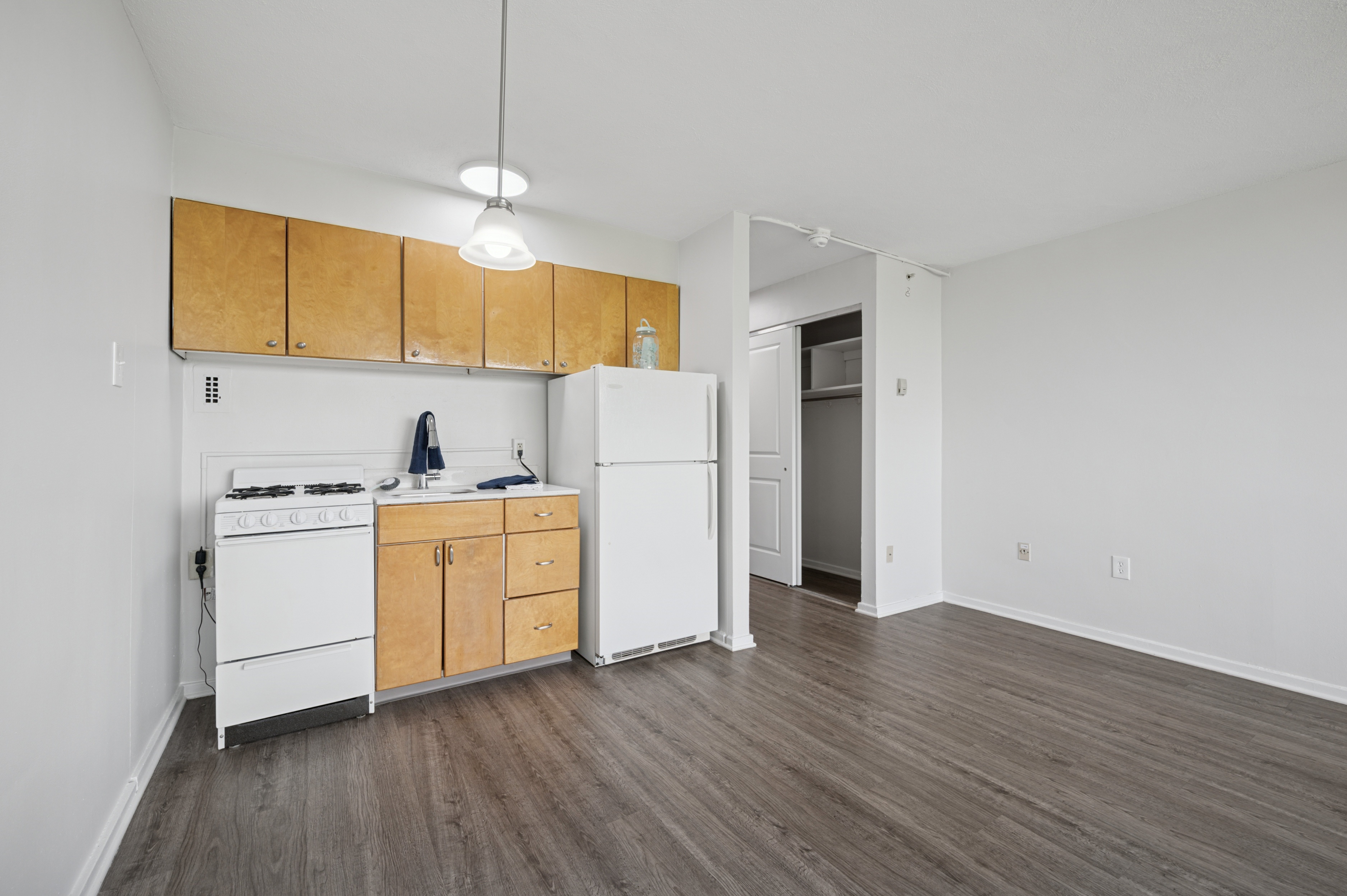A kitchen with white appliances and wooden cabinets.