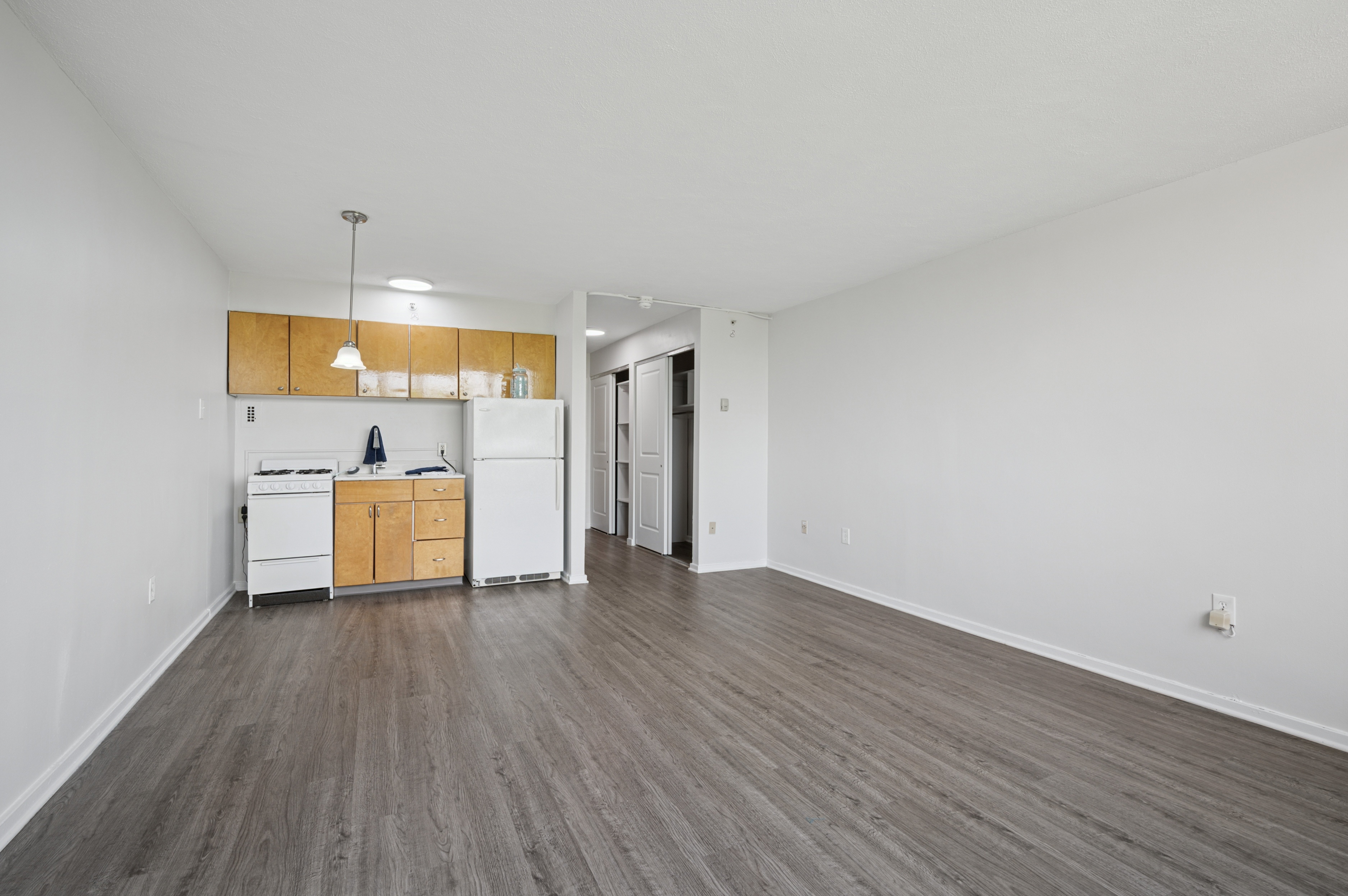 A kitchen with white appliances and wooden cabinets is in the image.