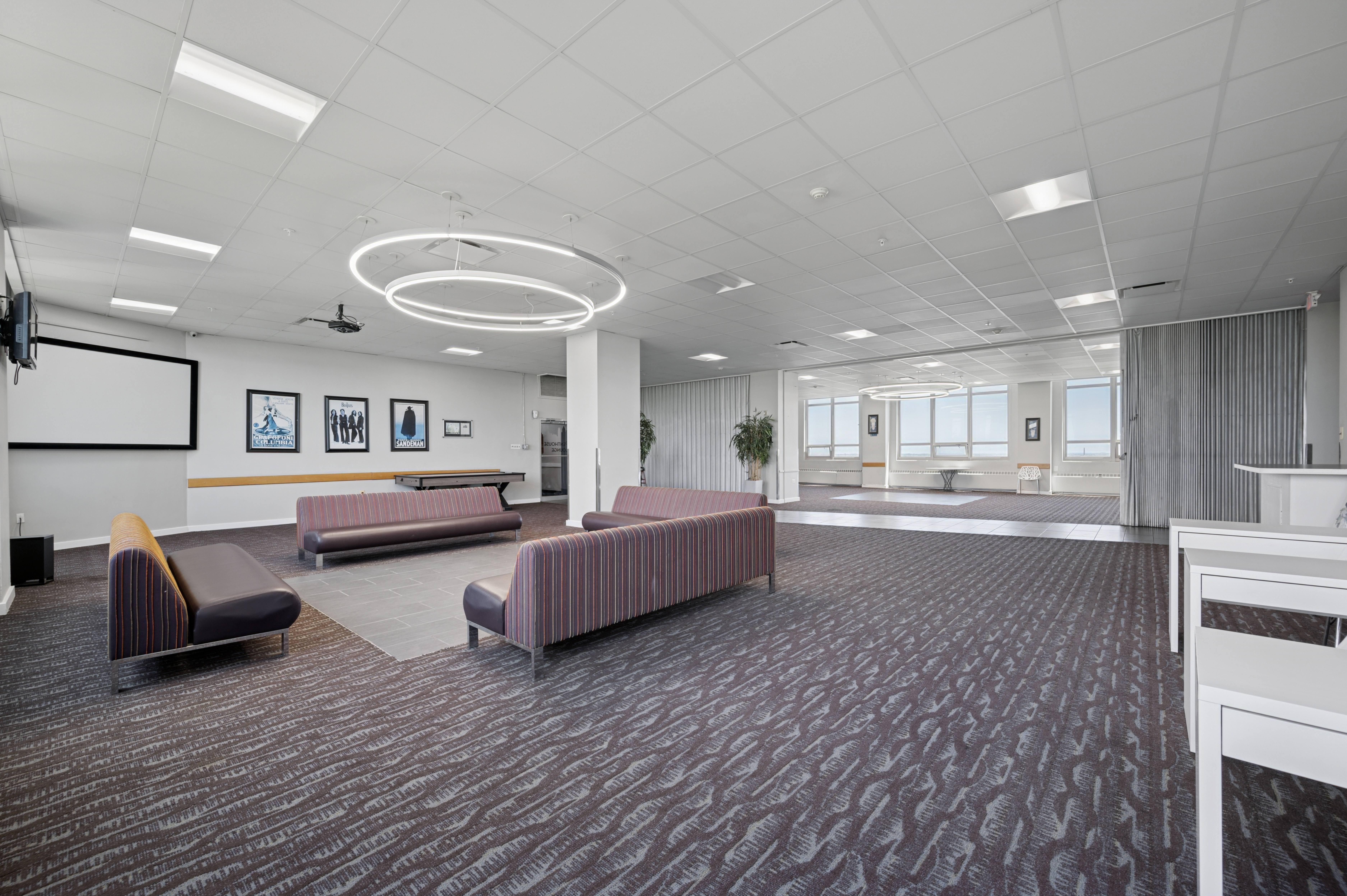A conference room with a carpeted floor and a whiteboard on the wall.